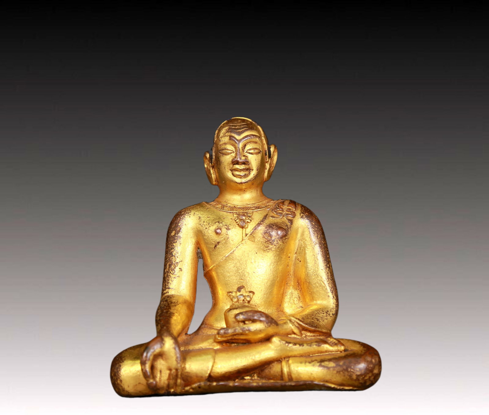 An exquisite gilt bronze statue of Guru: fine gilt bronze statue of the Guru with inscription,Ming Dynasty,China,dressed in traditional monk's robes,with a solemn,calm and wise expression on his face,reflecting the Guru's compassion and teac