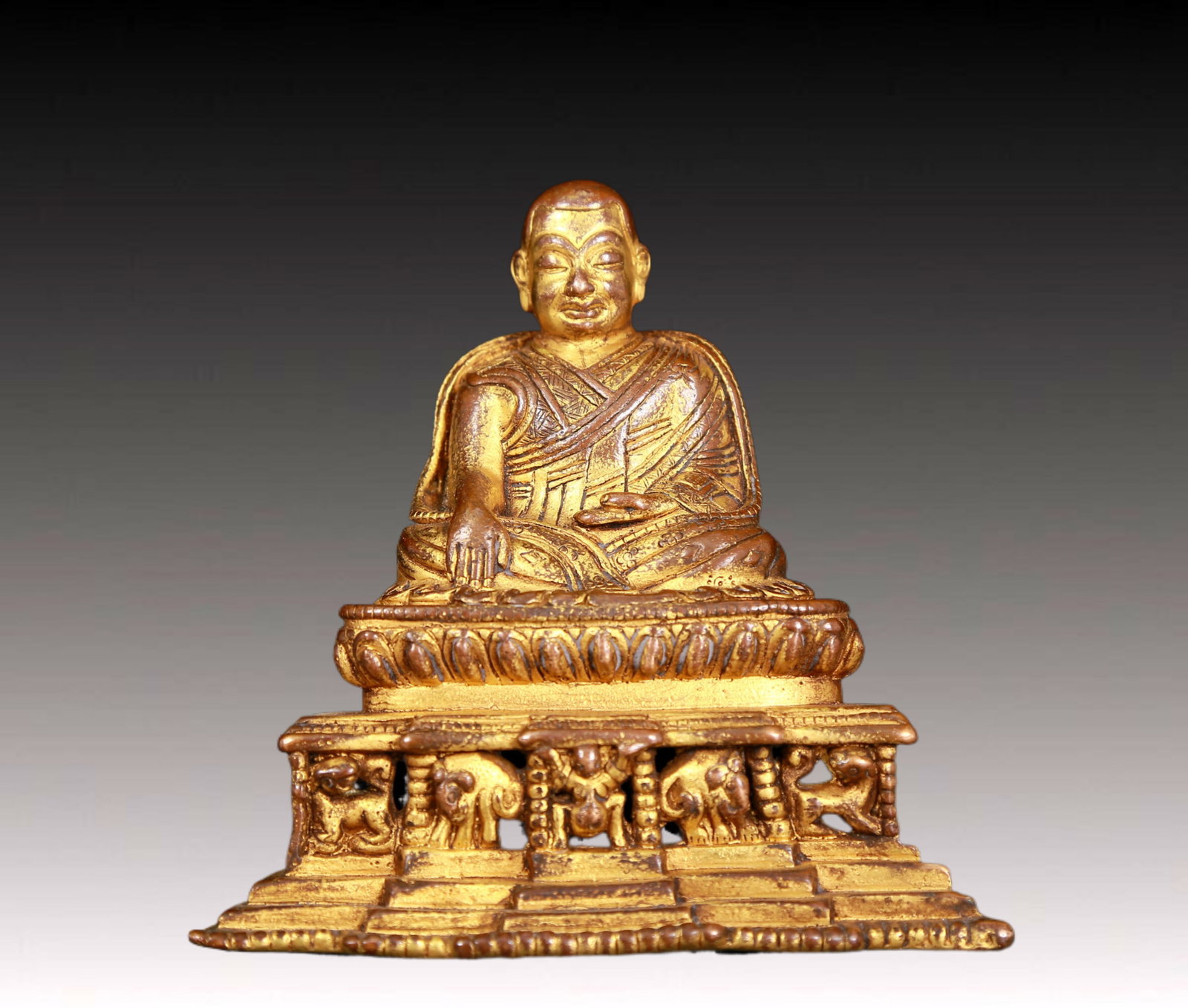 An exquisite gilt bronze statue of Tsongkhapa: fine gilt bronze statue of the Guru with inscription,Ming Dynasty,China,dressed in traditional monk's robes,with a solemn,calm and wise expression on his face,reflecting the Guru's compassion and teac