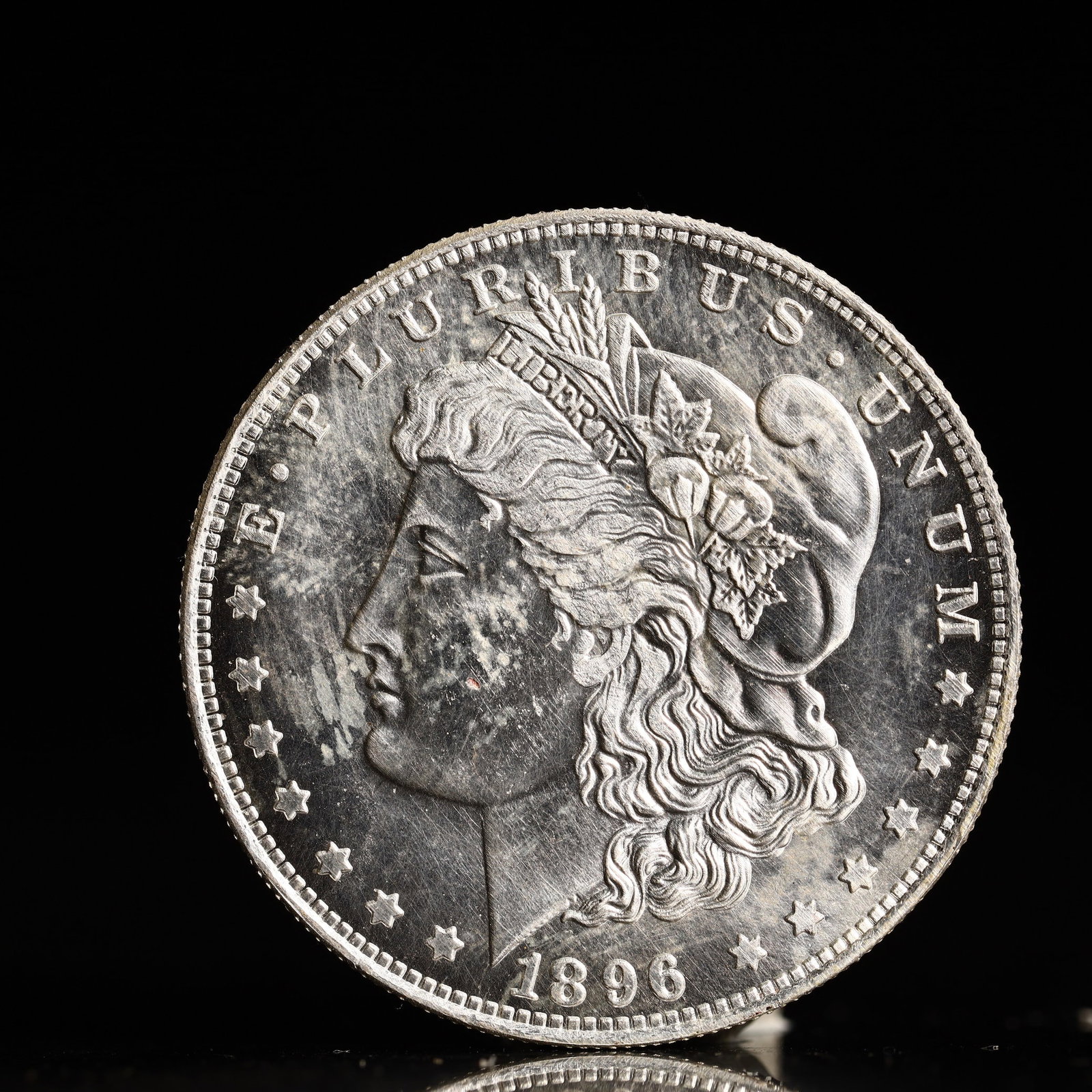 USA Morgan Dollar 1896 Coin: Obv: profile bust with date below and E PLURIBUS UNUM legend and stars around. Rev: eagle with In God we trust above within wreath with UNITED STATES OF AMERICA ONE DOLLAR legend. IN GOD WE TRUST / LI