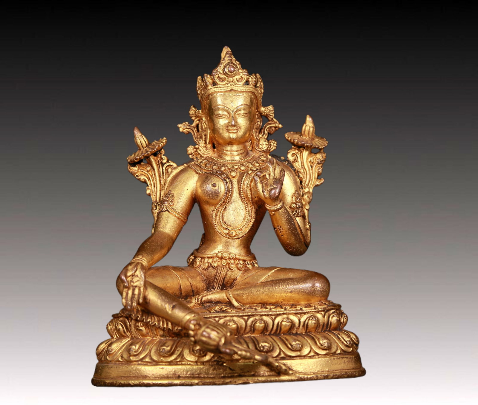 An exquisite gilt bronze statue of green Tara: An exquisite gilt-bronze green Tara statue,Ming Dynasty,China. Tara has an elegant posture with a peaceful and compassionate expression. Her face is soft and solemn,and her eyes are warm. She seems to