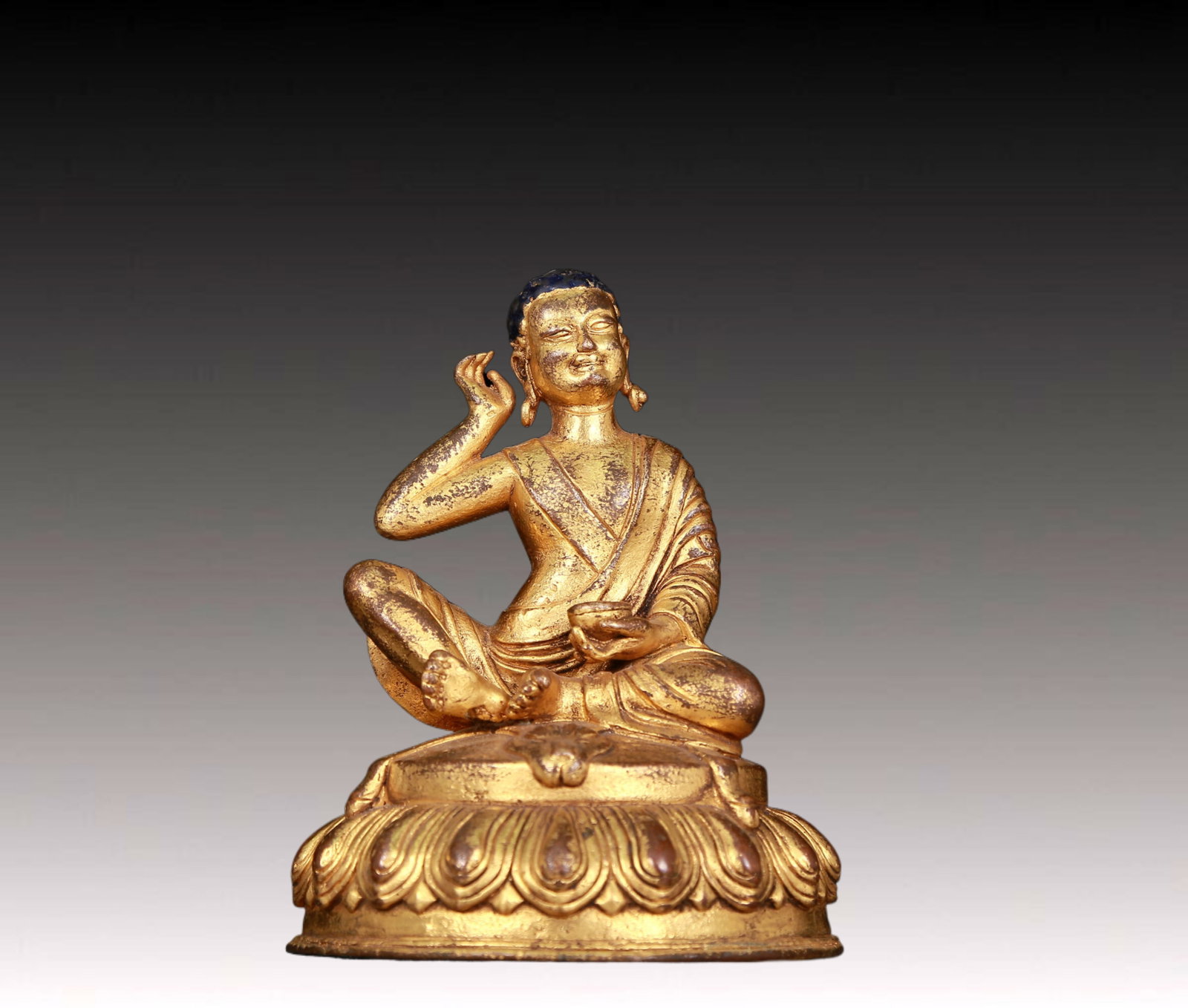 An exquisite gilt bronze statue of Tsongkhapa: An exquisite gilt bronze statue of Tsongkhapa,Ming Dynasty,China,dressed in traditional monk robes,with a solemn,calm and wise expression on his face,reflecting Tsongkhapa's compassion and teachings. 