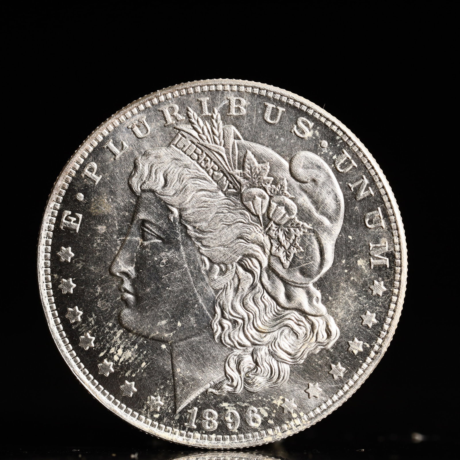 USA Morgan Dollar 1896 Coin: Obv: profile bust with date below and E PLURIBUS UNUM legend and stars around. Rev: eagle with In God we trust above within wreath with UNITED STATES OF AMERICA ONE DOLLAR legend. IN GOD WE TRUST / LI