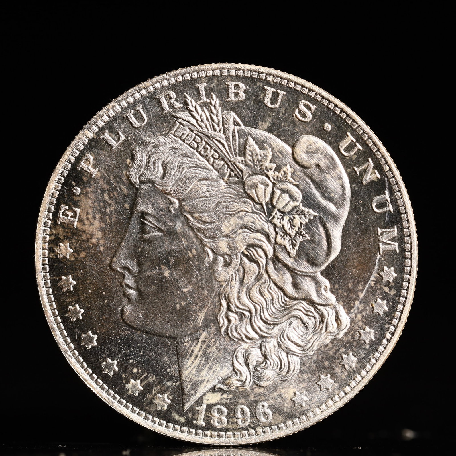 USA Morgan Dollar 1896 Coin: Obv: profile bust with date below and E PLURIBUS UNUM legend and stars around. Rev: eagle with In God we trust above within wreath with UNITED STATES OF AMERICA ONE DOLLAR legend. IN GOD WE TRUST / LI