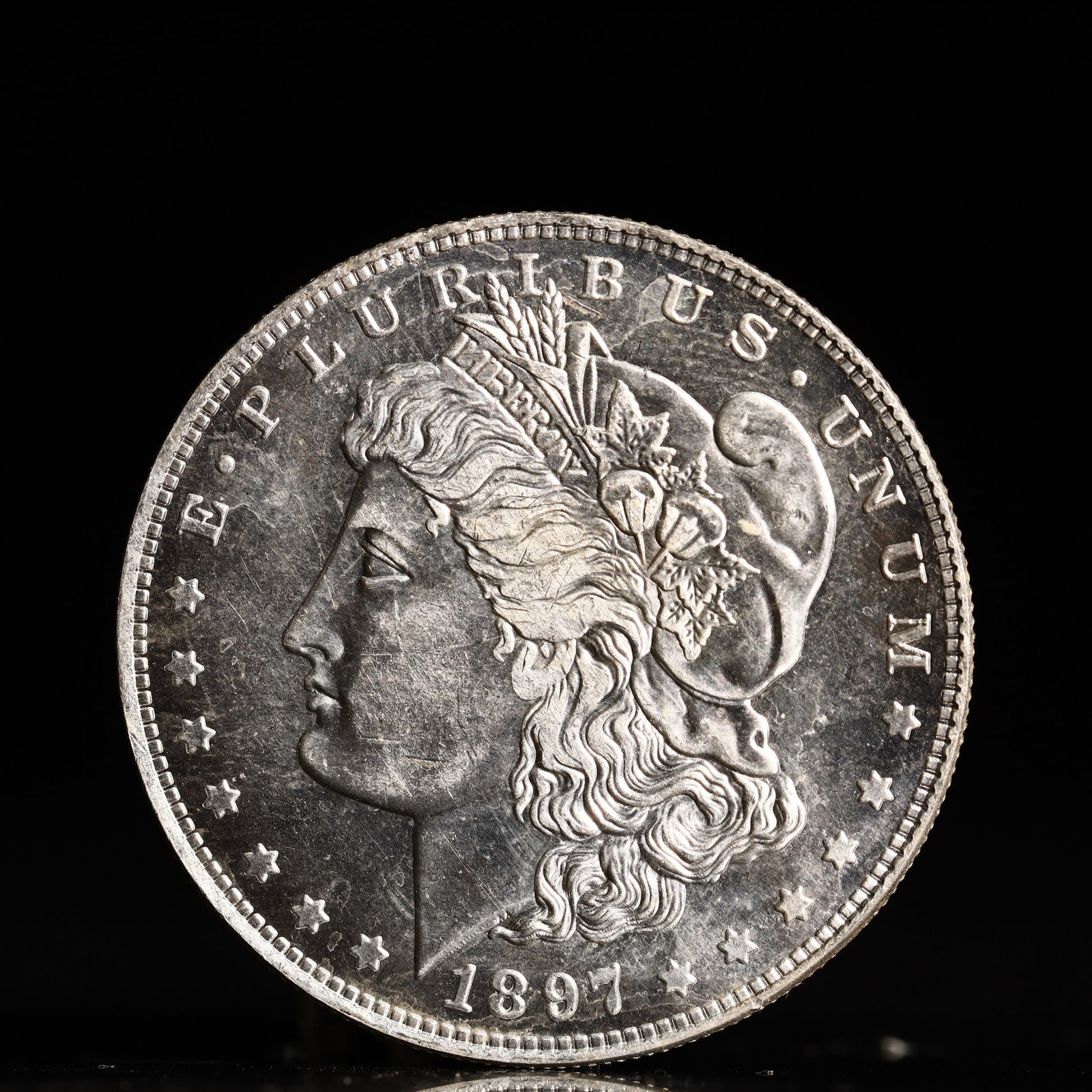 USA Morgan Dollar 1897 Coin: Obv: profile bust with date below and E PLURIBUS UNUM legend and stars around. Rev: eagle with In God we trust above within wreath with UNITED STATES OF AMERICA ONE DOLLAR legend. IN GOD WE TRUST / LI