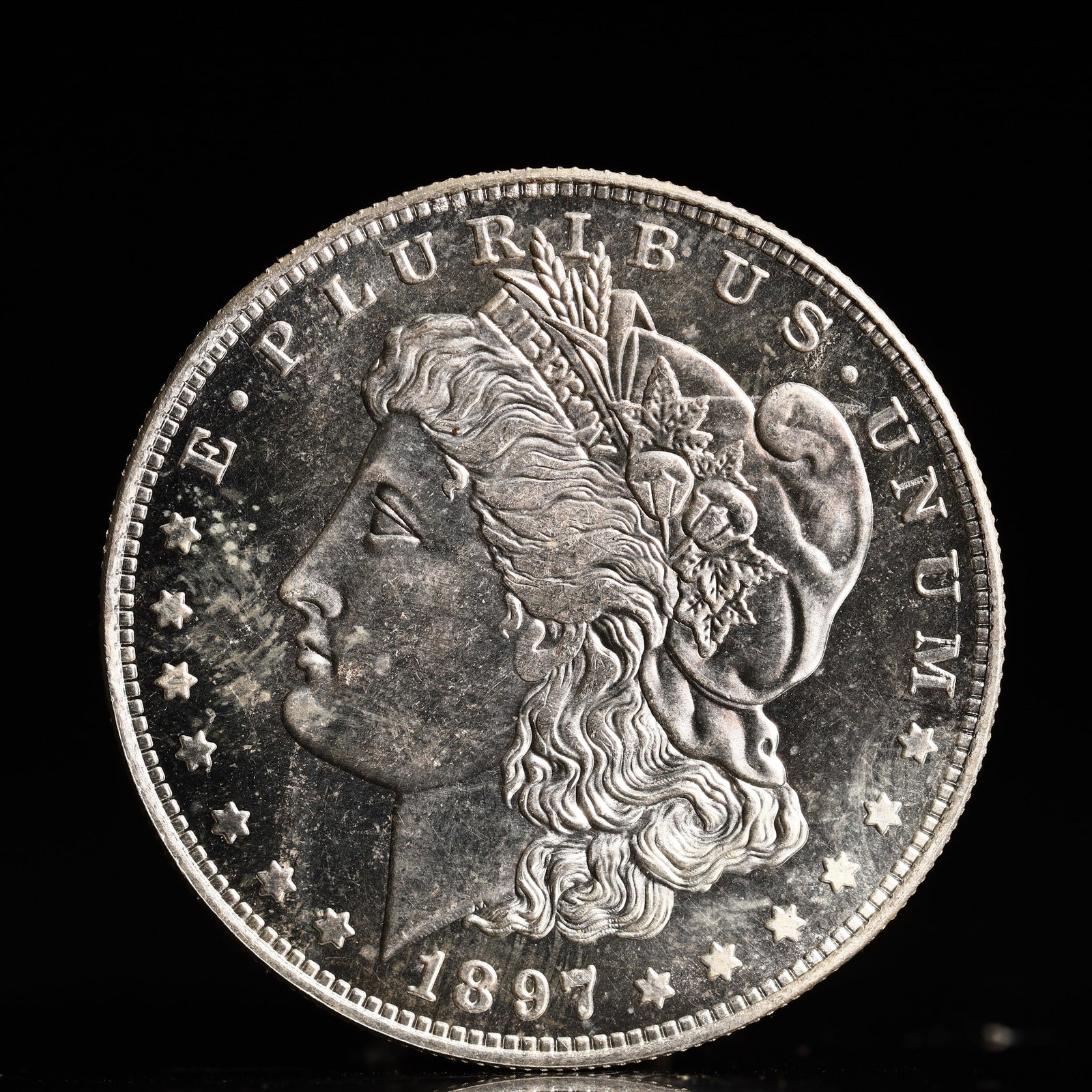 USA Morgan Dollar 1897 Coin: Obv: profile bust with date below and E PLURIBUS UNUM legend and stars around. Rev: eagle with In God we trust above within wreath with UNITED STATES OF AMERICA ONE DOLLAR legend. IN GOD WE TRUST / LI
