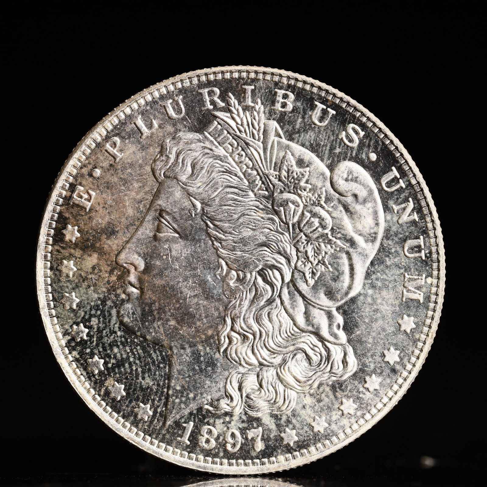 USA Morgan Dollar 1897 Coin: Obv: profile bust with date below and E PLURIBUS UNUM legend and stars around. Rev: eagle with In God we trust above within wreath with UNITED STATES OF AMERICA ONE DOLLAR legend. IN GOD WE TRUST / LI
