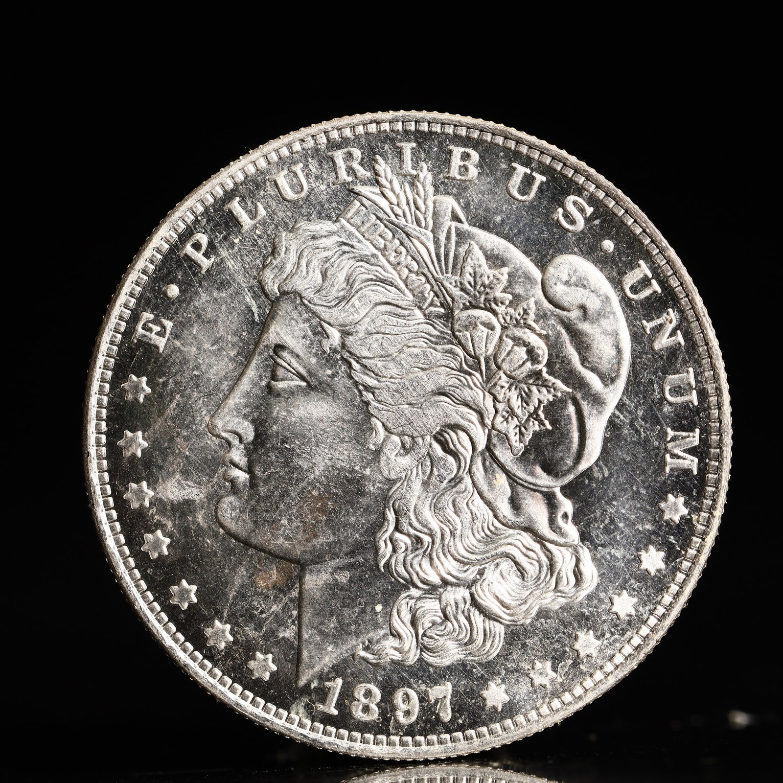 USA Morgan Dollar 1897 Coin: Obv: profile bust with date below and E PLURIBUS UNUM legend and stars around. Rev: eagle with In God we trust above within wreath with UNITED STATES OF AMERICA ONE DOLLAR legend. IN GOD WE TRUST / LI