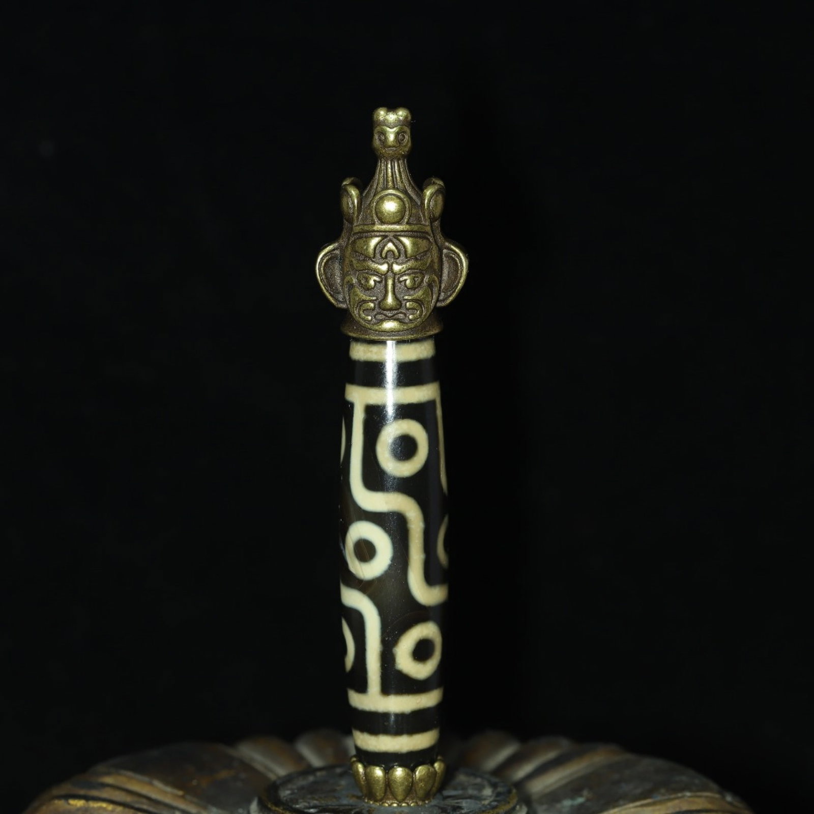 An Exquisite Inlaid Bronze Human-face Pattern Dzi Bead Pendant: An Exquisite Inlaid Bronze Human-face Pattern Dzi Bead Pendant,Size:86mmx12mm,Weight:30g 镶铜人面纹天珠挂件