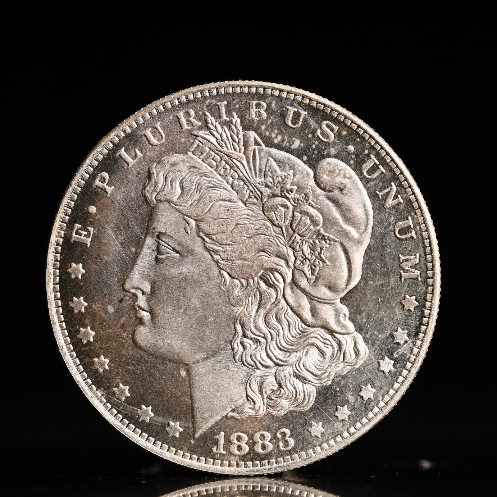 USA Morgan Dollar 1883 Coin: Obv: profile bust with date below and E PLURIBUS UNUM legend and stars around. Rev: eagle with In God we trust above within wreath with UNITED STATES OF AMERICA ONE DOLLAR legend. IN GOD WE TRUST / LI