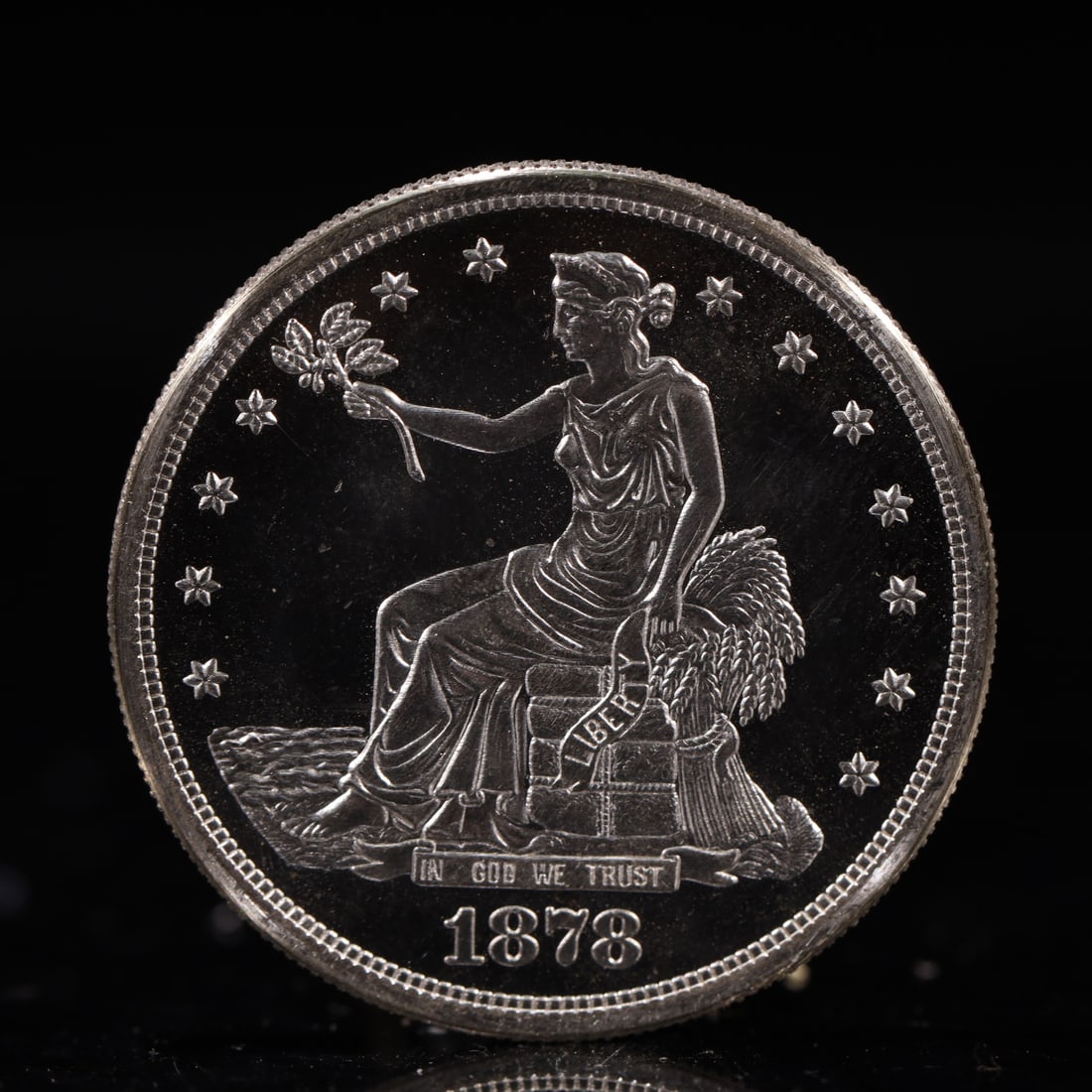 USA Trade Dollar 1878 Coin: American coin. Obverse: Liberty seated on a pedestal facing the sea to the left holding olive branches surrounded by 13 stars. IN GOD WE TRUST / LIBERTY / 1878. Reverse: An eagle holding branches with