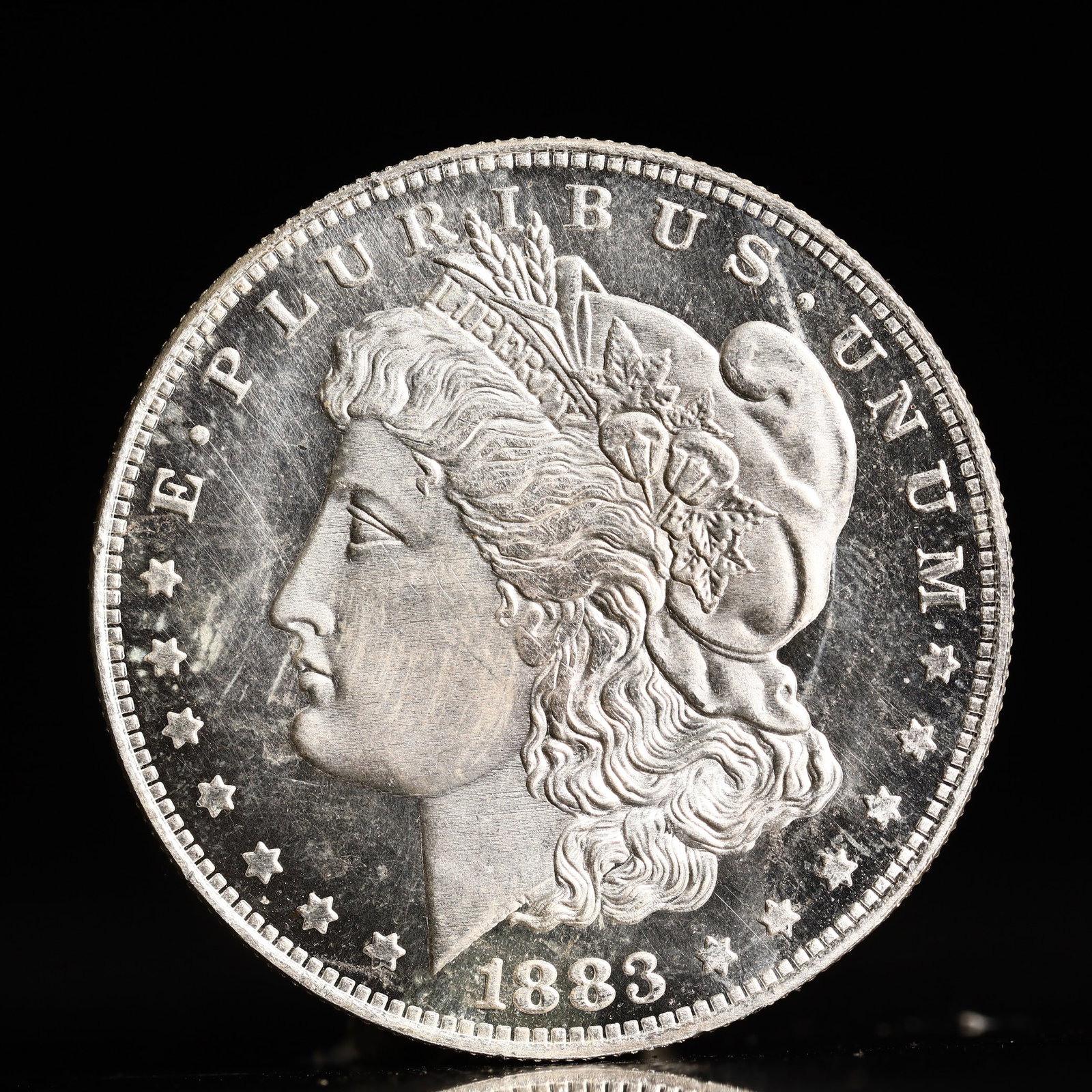 USA Morgan Dollar 1883 Coin: Obv: profile bust with date below and E PLURIBUS UNUM legend and stars around. Rev: eagle with In God we trust above within wreath with UNITED STATES OF AMERICA ONE DOLLAR legend. IN GOD WE TRUST / LI