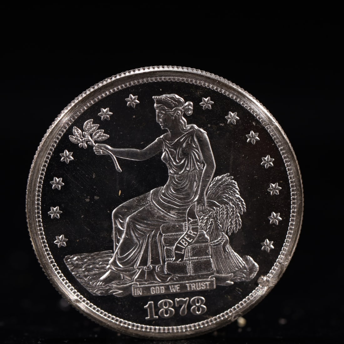 USA Trade Dollar 1878 Coin: American coin. Obverse: Liberty seated on a pedestal facing the sea to the left holding olive branches surrounded by 13 stars. IN GOD WE TRUST / LIBERTY / 1878. Reverse: An eagle holding branches with