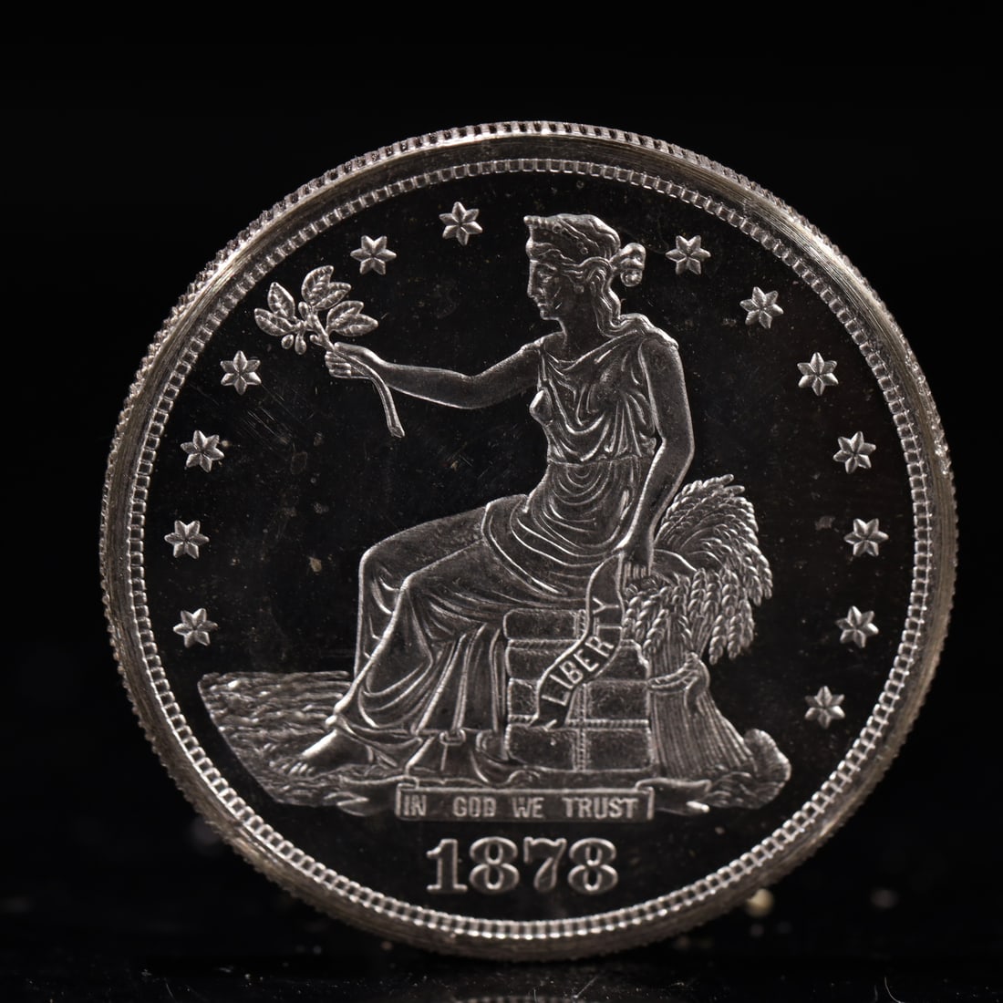 USA Trade Dollar 1878 Coin: American coin. Obverse: Liberty seated on a pedestal facing the sea to the left holding olive branches surrounded by 13 stars. IN GOD WE TRUST / LIBERTY / 1878. Reverse: An eagle holding branches with