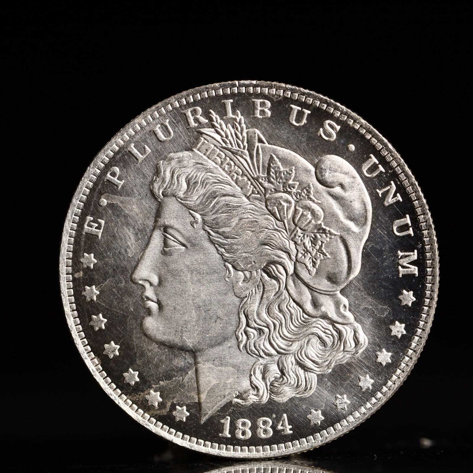 USA Morgan Dollar 1884 Coin: Obv: profile bust with date below and E PLURIBUS UNUM legend and stars around. Rev: eagle with In God we trust above within wreath with UNITED STATES OF AMERICA ONE DOLLAR legend. IN GOD WE TRUST / LI