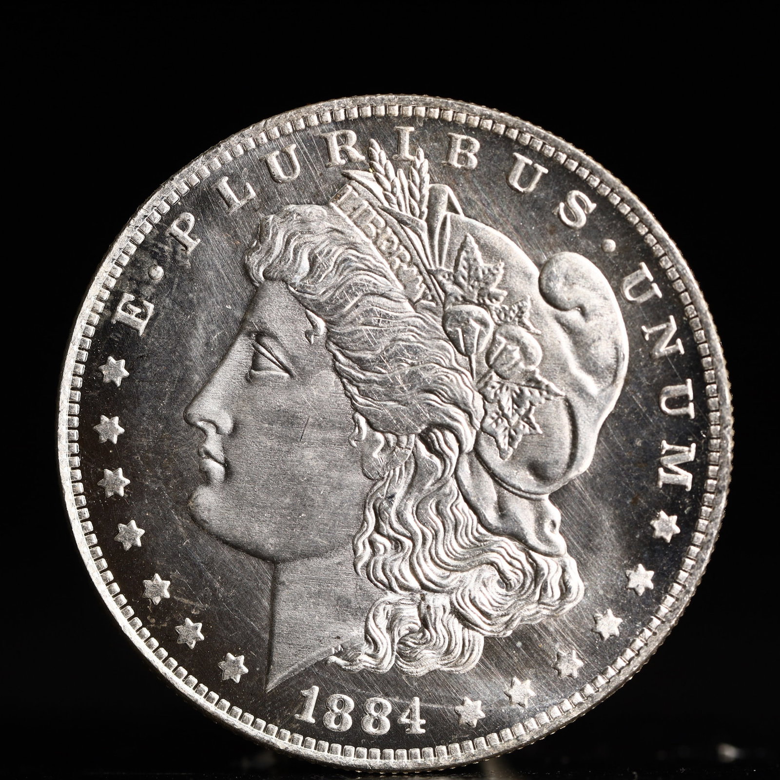 USA Morgan Dollar 1884 Coin: Obv: profile bust with date below and E PLURIBUS UNUM legend and stars around. Rev: eagle with In God we trust above within wreath with UNITED STATES OF AMERICA ONE DOLLAR legend. IN GOD WE TRUST / LI
