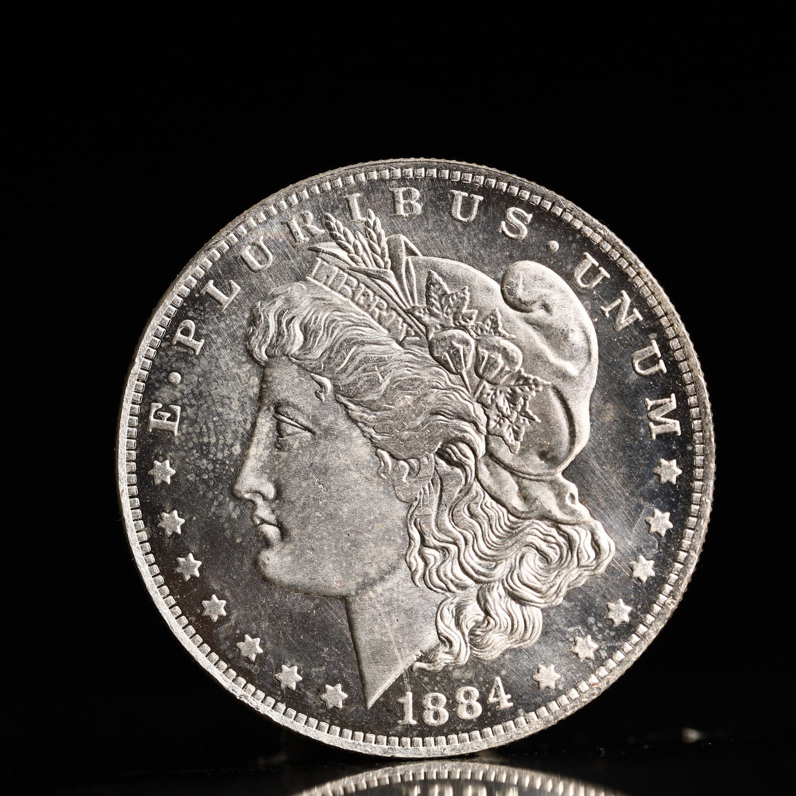 USA Morgan Dollar 1884 Coin: Obv: profile bust with date below and E PLURIBUS UNUM legend and stars around. Rev: eagle with In God we trust above within wreath with UNITED STATES OF AMERICA ONE DOLLAR legend. IN GOD WE TRUST / LI