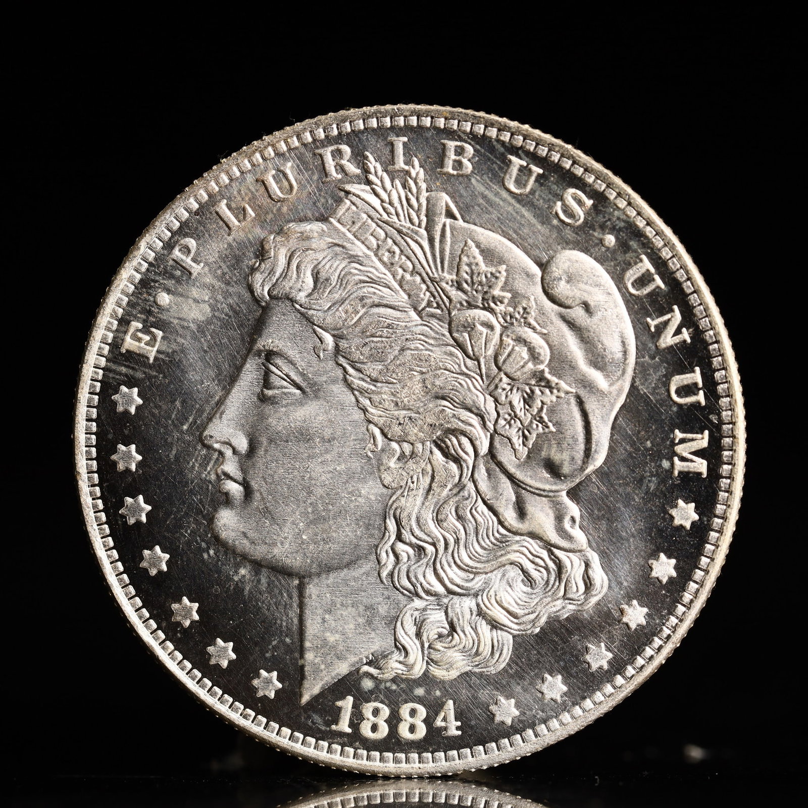 USA Morgan Dollar 1884 Coin: Obv: profile bust with date below and E PLURIBUS UNUM legend and stars around. Rev: eagle with In God we trust above within wreath with UNITED STATES OF AMERICA ONE DOLLAR legend. IN GOD WE TRUST / LI