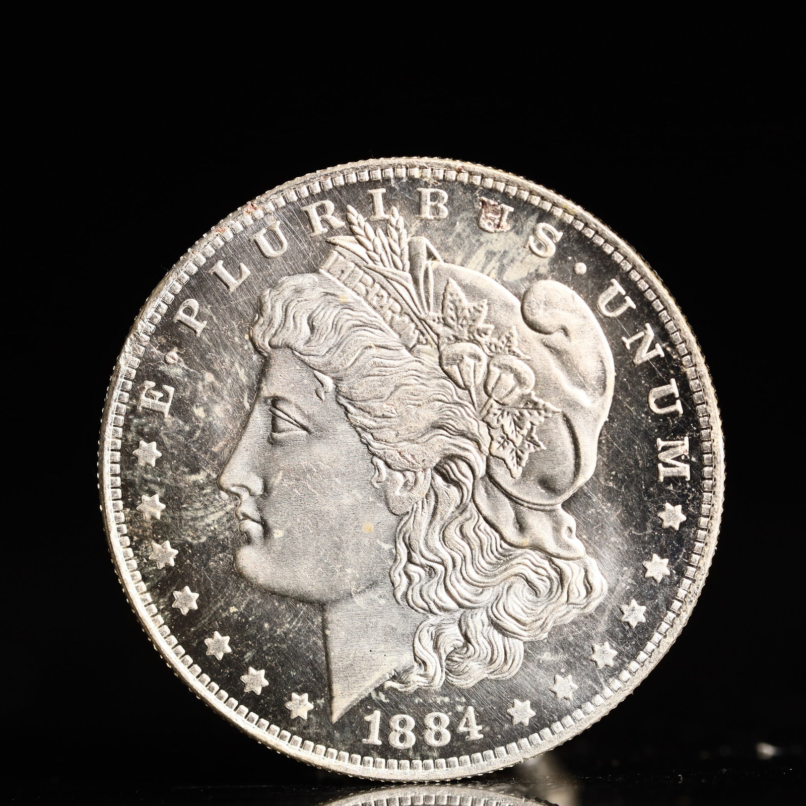 USA Morgan Dollar 1884 Coin: Obv: profile bust with date below and E PLURIBUS UNUM legend and stars around. Rev: eagle with In God we trust above within wreath with UNITED STATES OF AMERICA ONE DOLLAR legend. IN GOD WE TRUST / LI