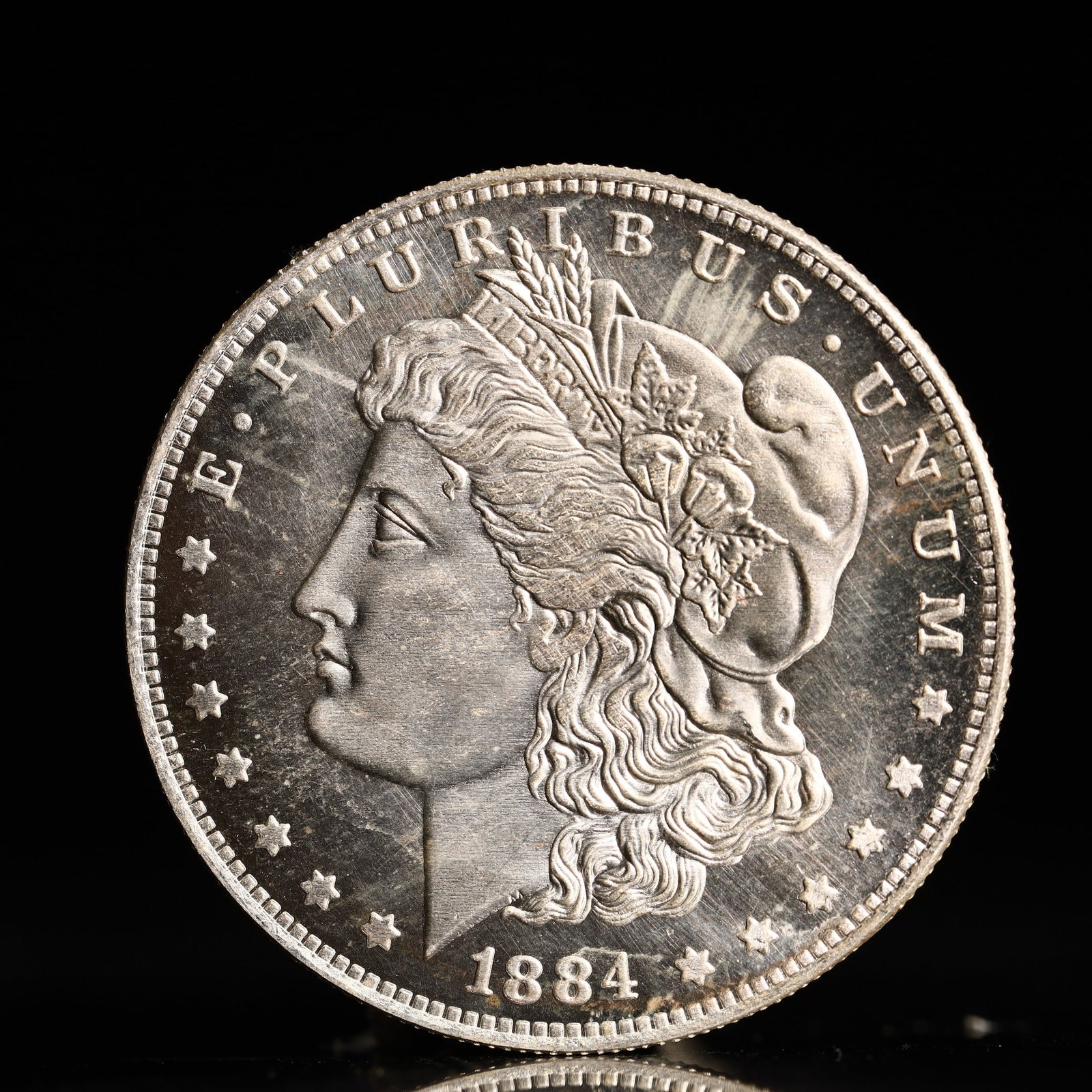 USA Morgan Dollar 1884 Coin: Obv: profile bust with date below and E PLURIBUS UNUM legend and stars around. Rev: eagle with In God we trust above within wreath with UNITED STATES OF AMERICA ONE DOLLAR legend. IN GOD WE TRUST / LI