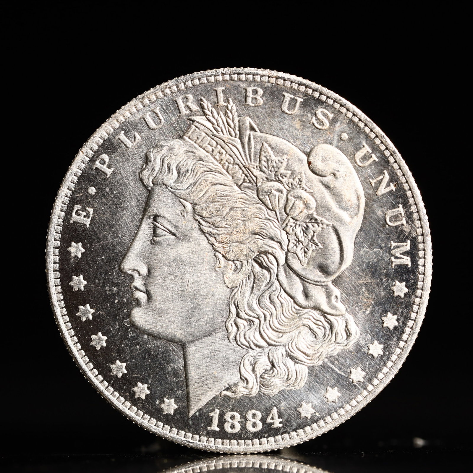 USA Morgan Dollar 1884 Coin: Obv: profile bust with date below and E PLURIBUS UNUM legend and stars around. Rev: eagle with In God we trust above within wreath with UNITED STATES OF AMERICA ONE DOLLAR legend. IN GOD WE TRUST / LI