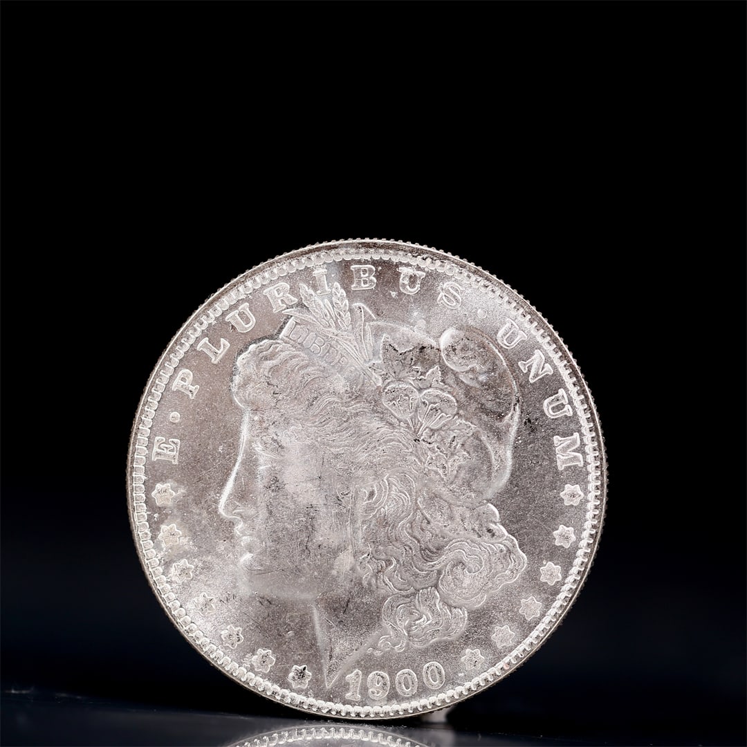 USA Morgan Dollar 1900 Coin: Obv: profile bust with date below and E PLURIBUS UNUM legend and stars around. Rev: eagle with In God we trust above within wreath with UNITED STATES OF AMERICA ONE DOLLAR legend. IN GOD WE TRUST / LI