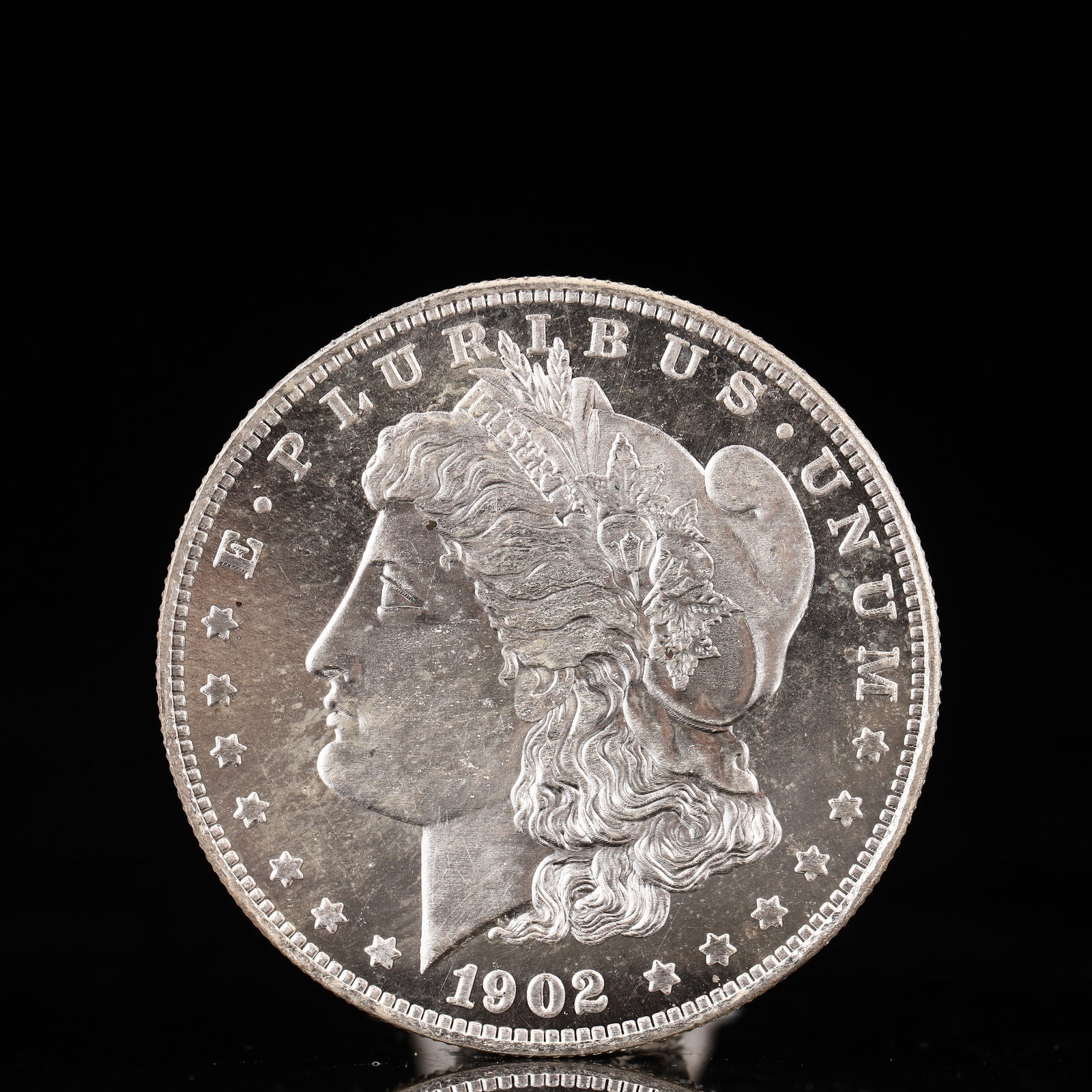 USA Morgan Dollar 1902 Coin: Obv: profile bust with date below and E PLURIBUS UNUM legend and stars around. Rev: eagle with In God we trust above within wreath with UNITED STATES OF AMERICA ONE DOLLAR legend. IN GOD WE TRUST / LI