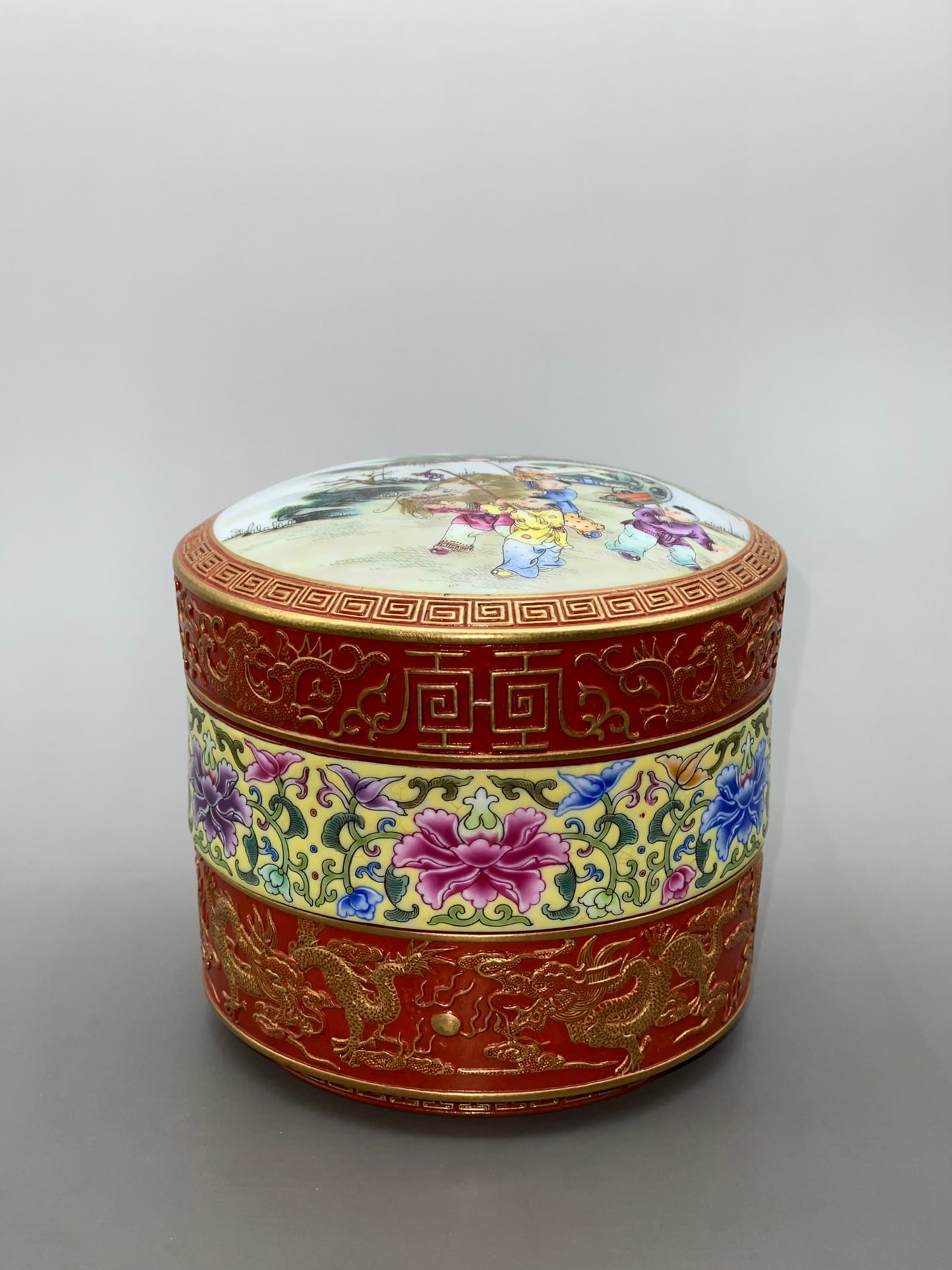 An Exquisite Iron-Red Glazed Yellow Ground Famille-Rose Painted Gold Lotus,Figure and Dragon Pattern: An Exquisite Iron-Red Glazed Yellow Ground Famille-Rose Painted Gold Lotus,Figure and Dragon Pattern Cover Box,Qing Dynasty,China,Qianlong Four-character Mark,Size:4.6inx4.8inx4.1in矾红