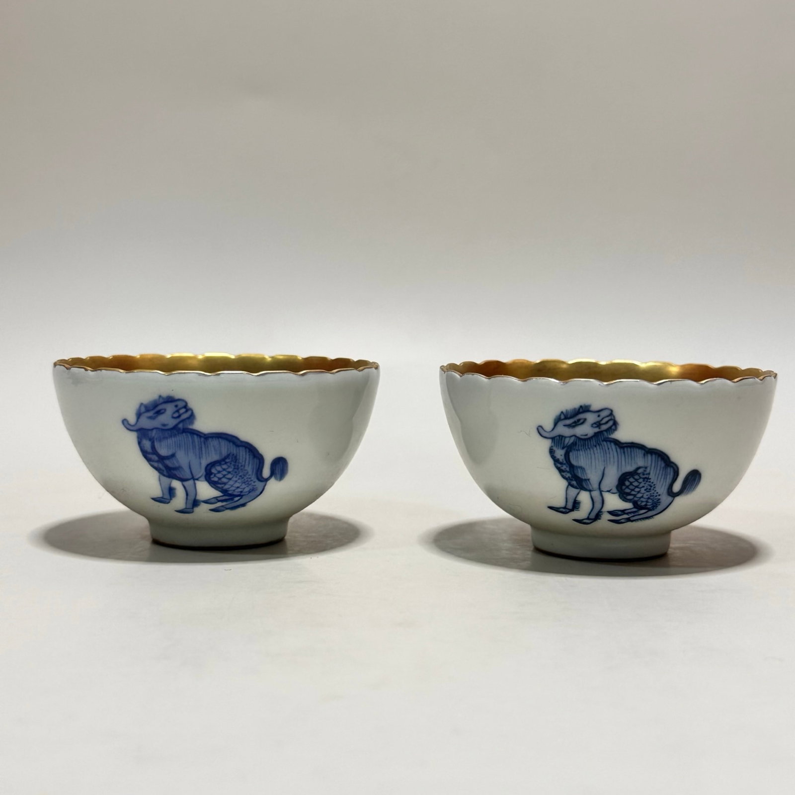 A Pair of Exquisite Blue and White Gold Ground Auspicious Beast Pattern Cups: A Pair of Exquisite Blue and White Gold Ground Auspicious Beast Pattern Cups,Qing Dynasty,China,Kangxi Six-character Mark,Size:1.6inx2.9in 一对青花金地瑞Ð