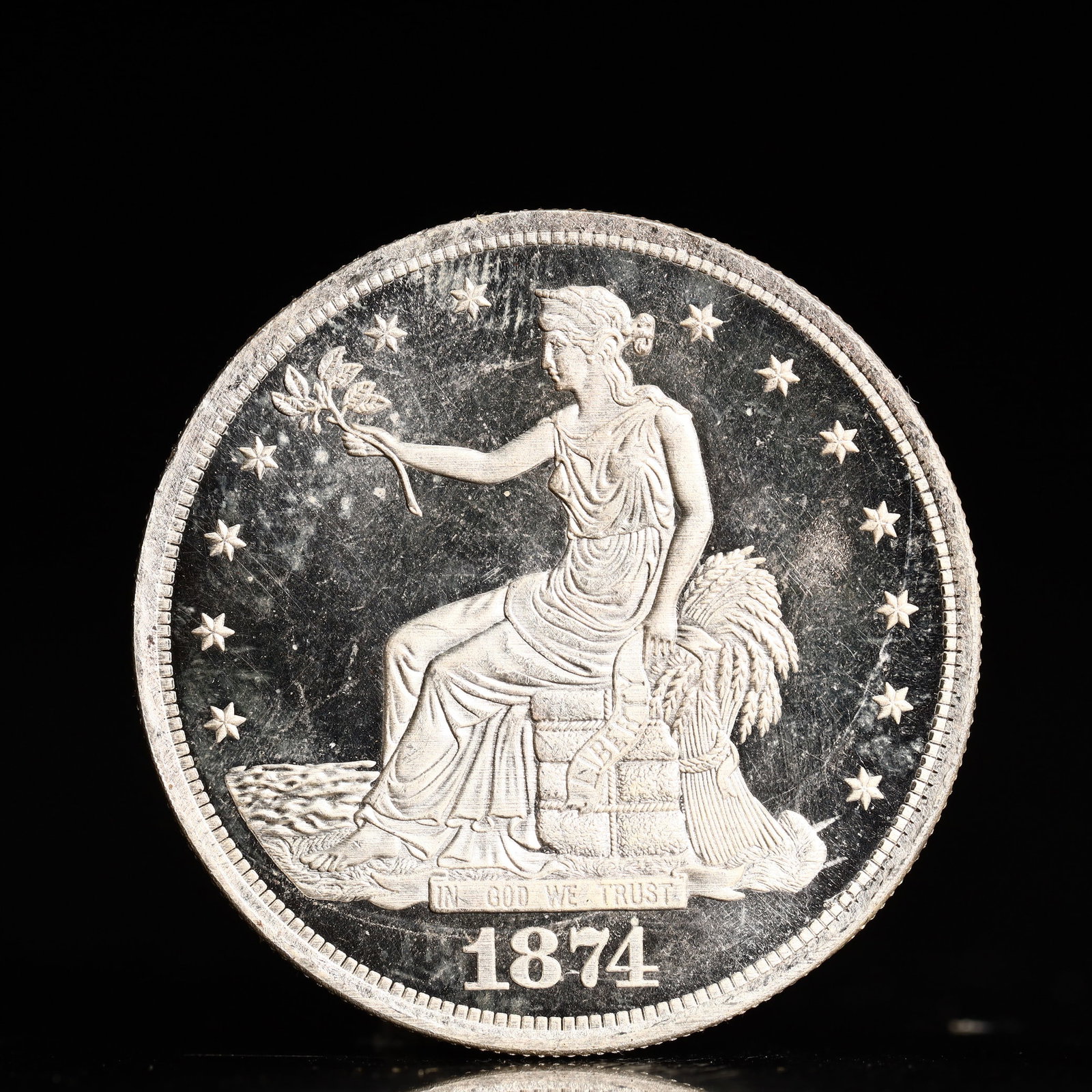 USA Trade Dollar 1874 Coin: American coin. Obverse: Liberty seated on a pedestal facing the sea to the left holding olive branches surrounded by 13 stars. IN GOD WE TRUST / LIBERTY / 1874. Reverse: An eagle holding branches with