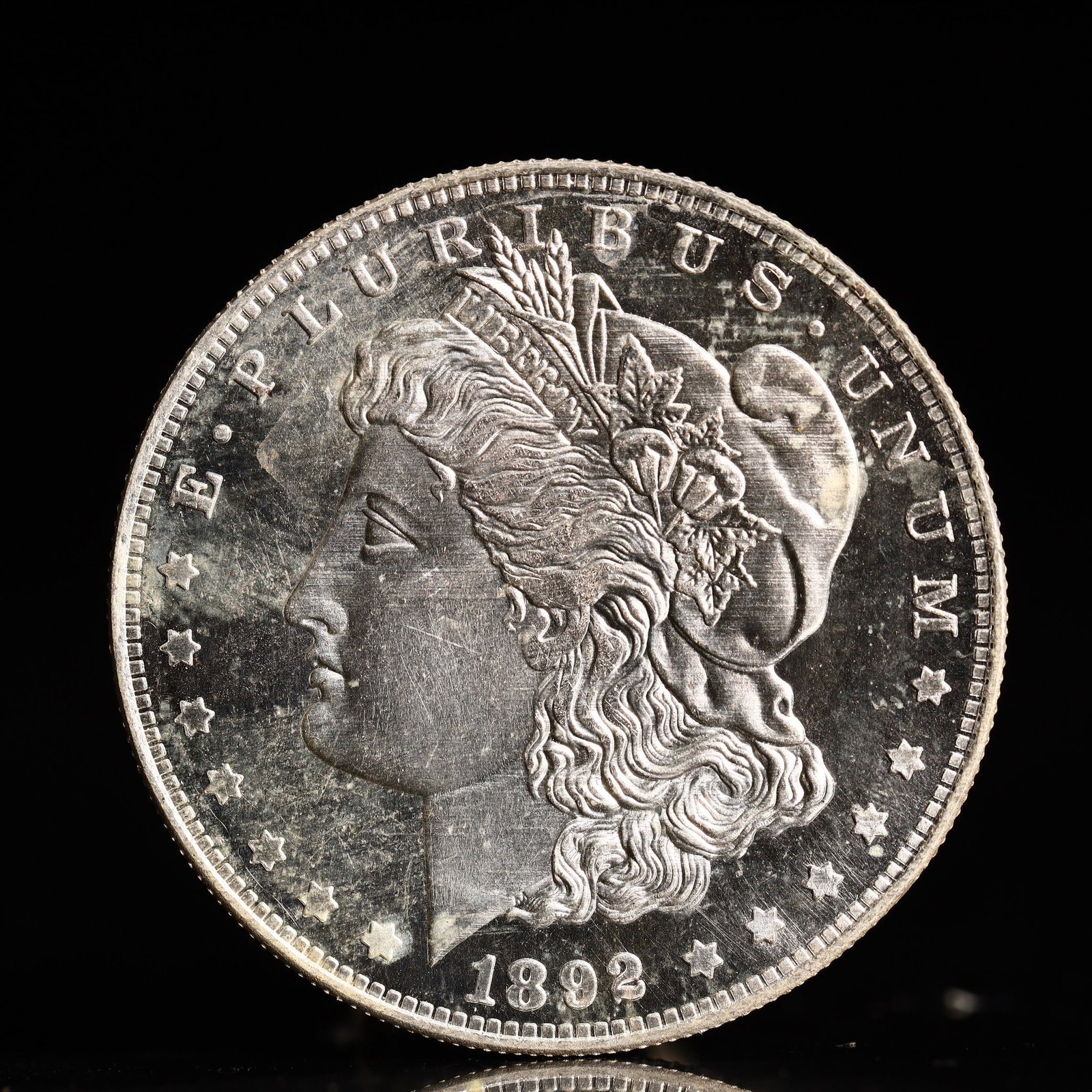 USA Morgan Dollar 1892 Coin: Obv: profile bust with date below and E PLURIBUS UNUM legend and stars around. Rev: eagle with In God we trust above within wreath with UNITED STATES OF AMERICA ONE DOLLAR legend. IN GOD WE TRUST / LI