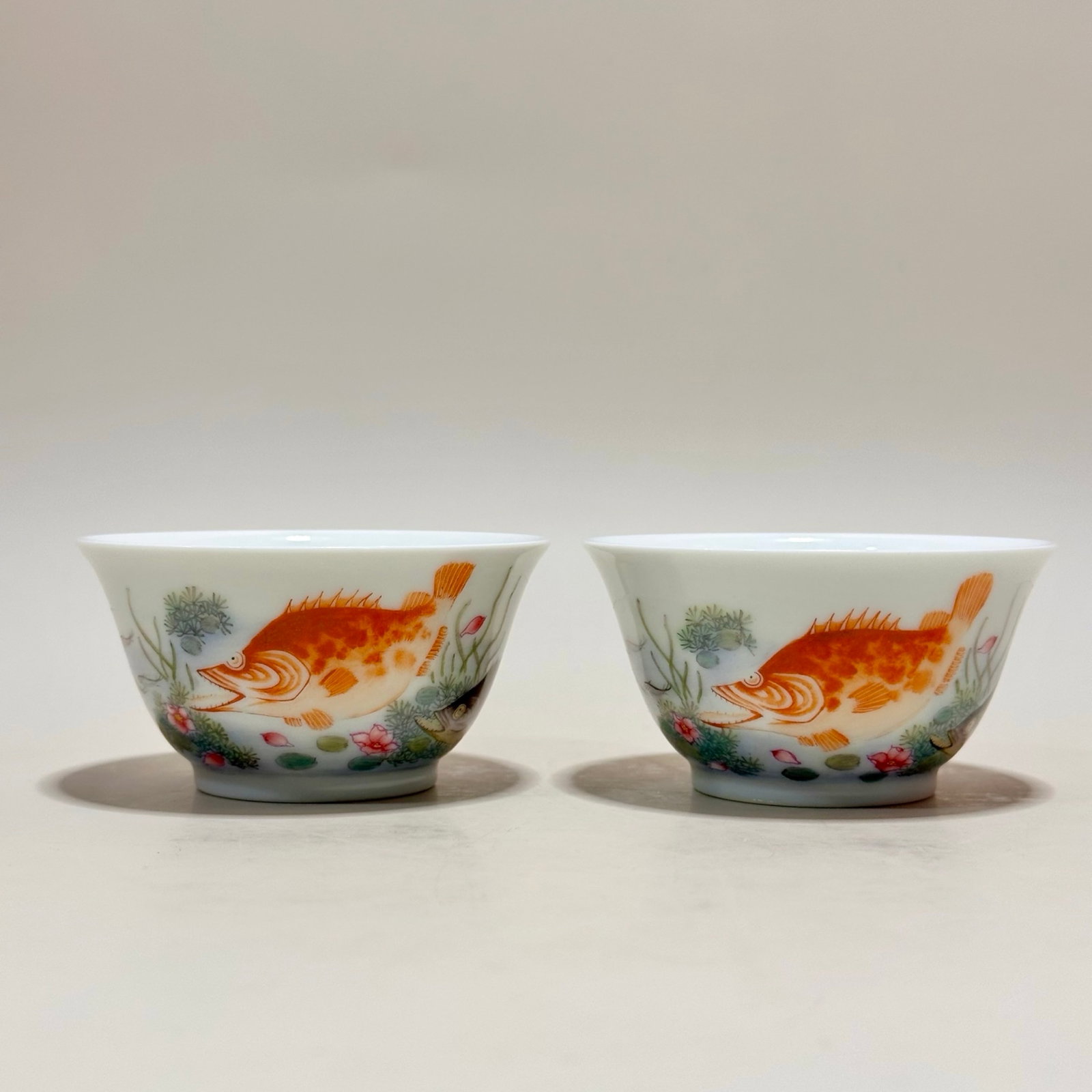 A Pair of Exquisite Famille-Rose Flower and Fish Pattern Cups: A Pair of Exquisite Famille-Rose Flower and Fish Pattern Cups,Qing Dynasty,China,Yongzheng Four-character Mark,Size:1.6inx3in 一对粉彩花卉鱼纹杯&#