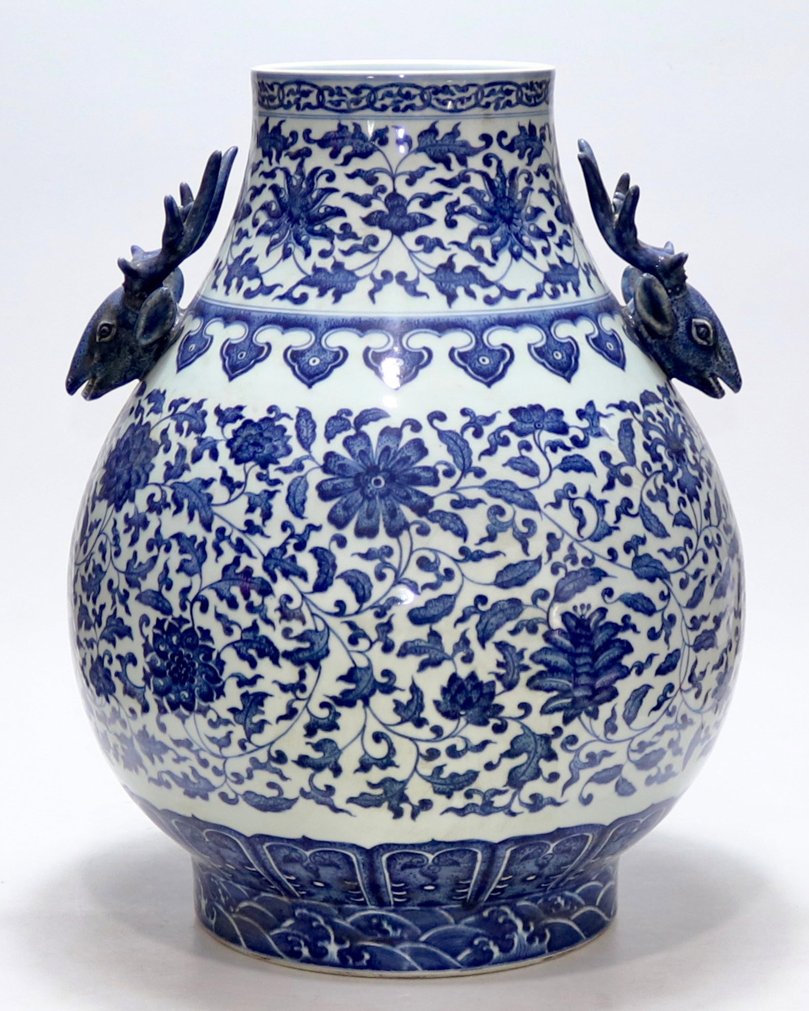 A fine blue and white deer-head zun vase with scrolling floral pattern: A fine blue and white deer-head zun vase with scrolling floral pattern, Qing Dynasty, China, with six-character Qianlong reign mark, Size:18.7inx6.4inA fine blue and white deer-head zun vase with scro