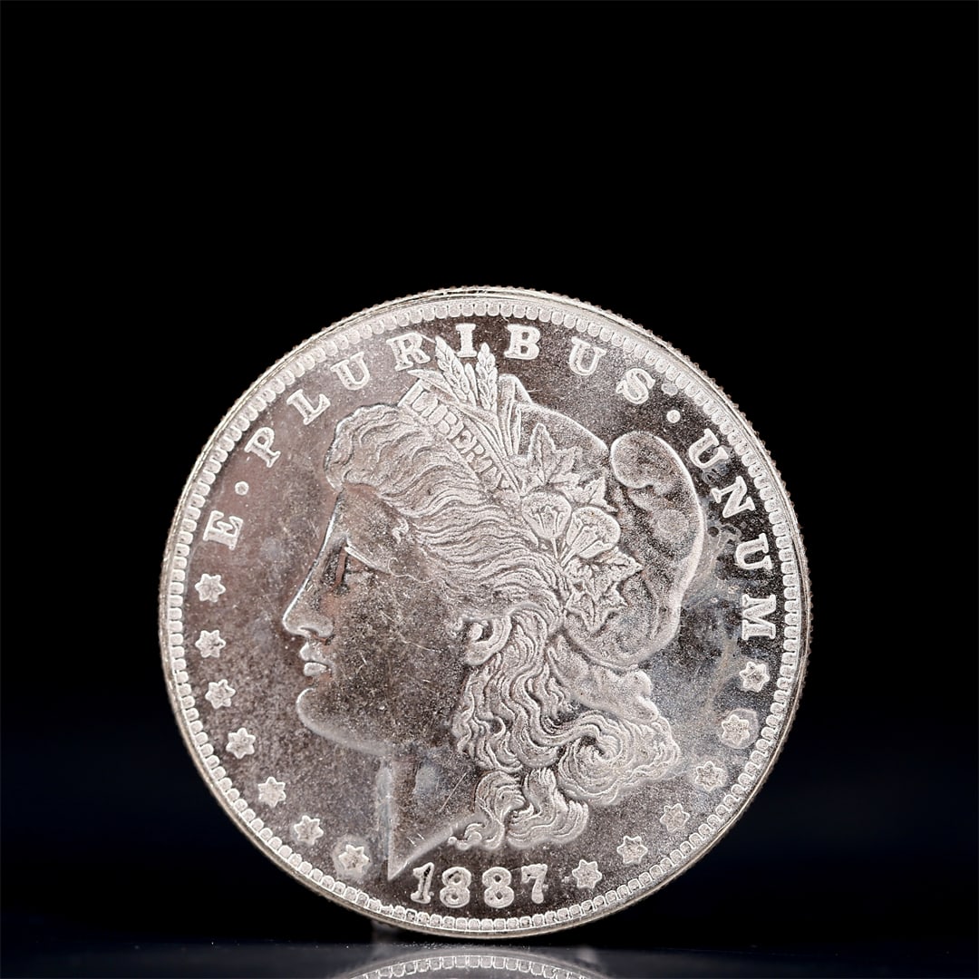 USA Morgan Dollar 1887 Coin: Obv: profile bust with date below and E PLURIBUS UNUM legend and stars around. Rev: eagle with In God we trust above within wreath with UNITED STATES OF AMERICA ONE DOLLAR legend. IN GOD WE TRUST /