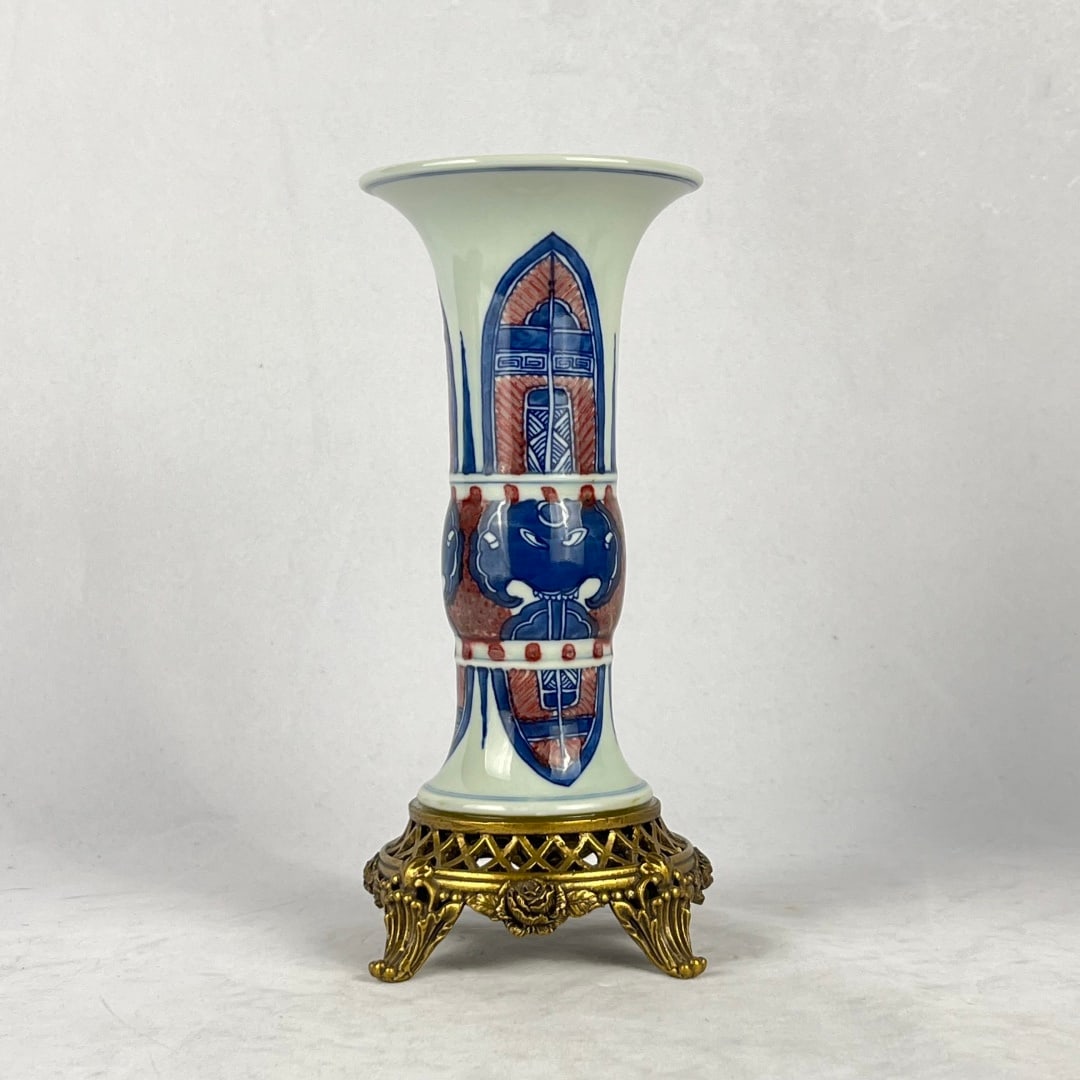 An Exquisite Blue And White Underglaze Red Gu Vase With Copper Base,Beast Mask And Banana Leaf: An Exquisite Blue And White Underglaze Red Gu Vase With Copper Base,Beast Mask And Banana Leaf Pattern,China Ming Dynasty,Dimensions:9.4inx4.1in,青花釉里红兽面