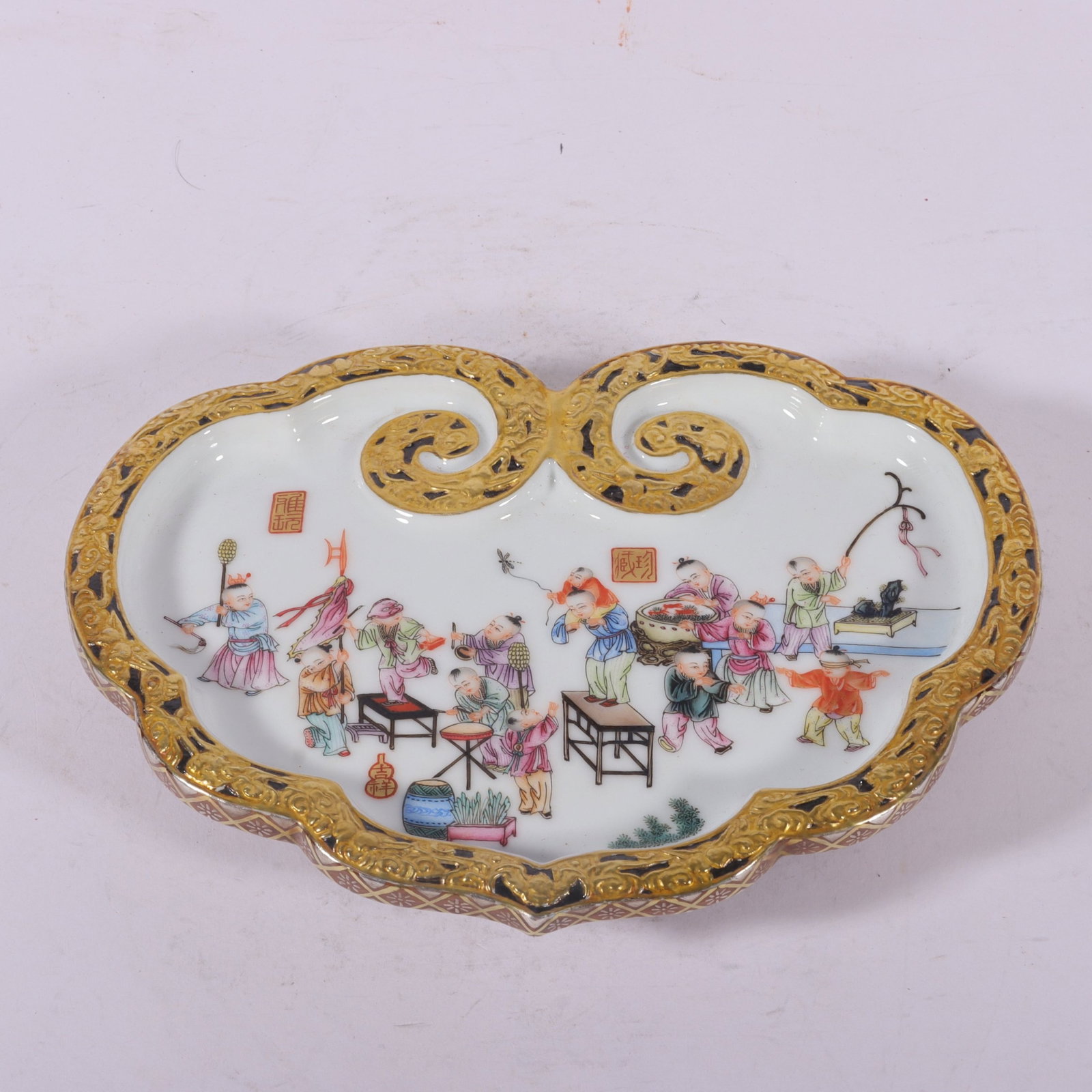 A Fine Enamel Color Carved and Gilt Children-at-Play Teapot Stand: A Fine Enamel Color Carved and Gilt Children-at-Play Teapot Stand,Qing Dynasty,China,Qianlong Six-character Mark,Size:1.2inx7.9inx5.9in,珐琅彩雕刻描金婴