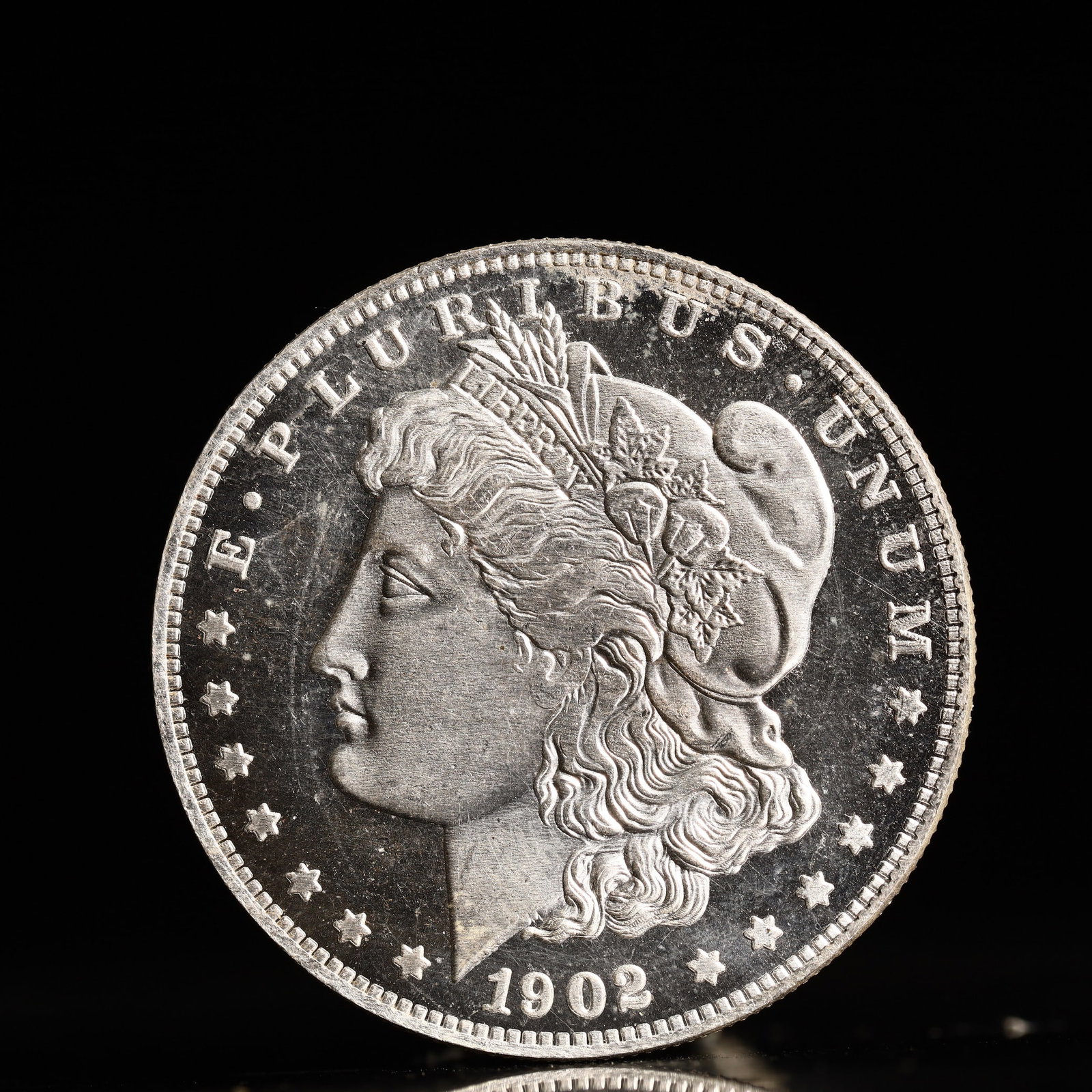 USA Morgan Dollar 1902 Coin: Obv: profile bust with date below and E PLURIBUS UNUM legend and stars around. Rev: eagle with In God we trust above within wreath with UNITED STATES OF AMERICA ONE DOLLAR legend. IN GOD WE TRUST / LI