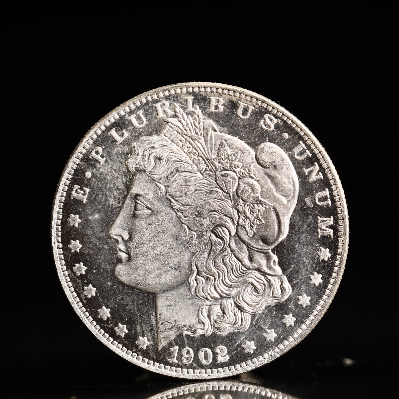 USA Morgan Dollar 1902 Coin: Obv: profile bust with date below and E PLURIBUS UNUM legend and stars around. Rev: eagle with In God we trust above within wreath with UNITED STATES OF AMERICA ONE DOLLAR legend. IN GOD WE TRUST / LI