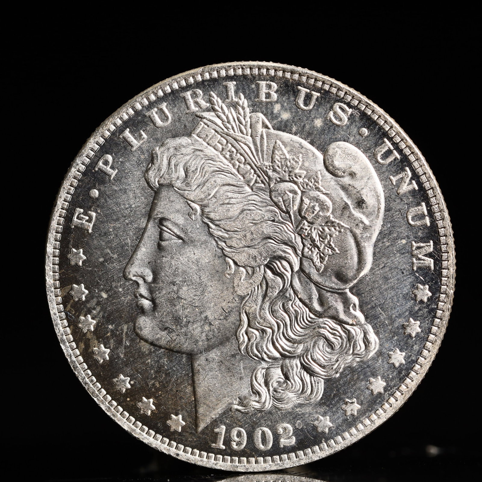 USA Morgan Dollar 1902 Coin: Obv: profile bust with date below and E PLURIBUS UNUM legend and stars around. Rev: eagle with In God we trust above within wreath with UNITED STATES OF AMERICA ONE DOLLAR legend. IN GOD WE TRUST / LI