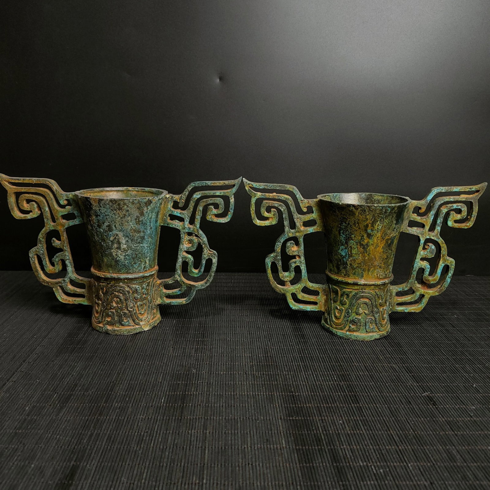A Pair Of Fine Openwork Bronze Phoenix?Eared Cups: A Pair Of Fine Openwork Bronze Phoenix‑Eared Cups,Chinese Warring States Period,Dimensions:8.7inx5.5inx3.5in,Weight:2200g,一对青铜镂空凤耳杯