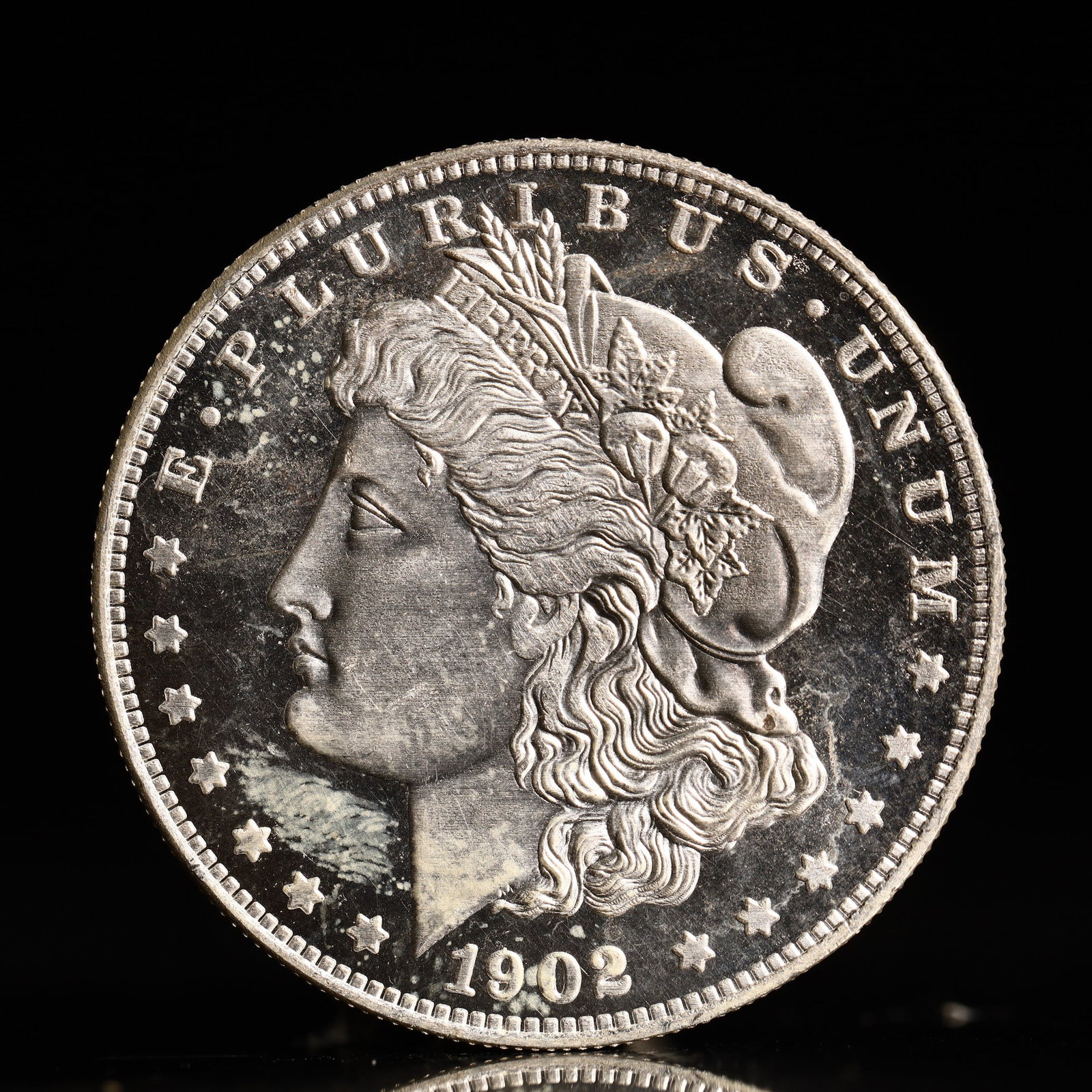 USA Morgan Dollar 1902 Coin: Obv: profile bust with date below and E PLURIBUS UNUM legend and stars around. Rev: eagle with In God we trust above within wreath with UNITED STATES OF AMERICA ONE DOLLAR legend. IN GOD WE TRUST / LI