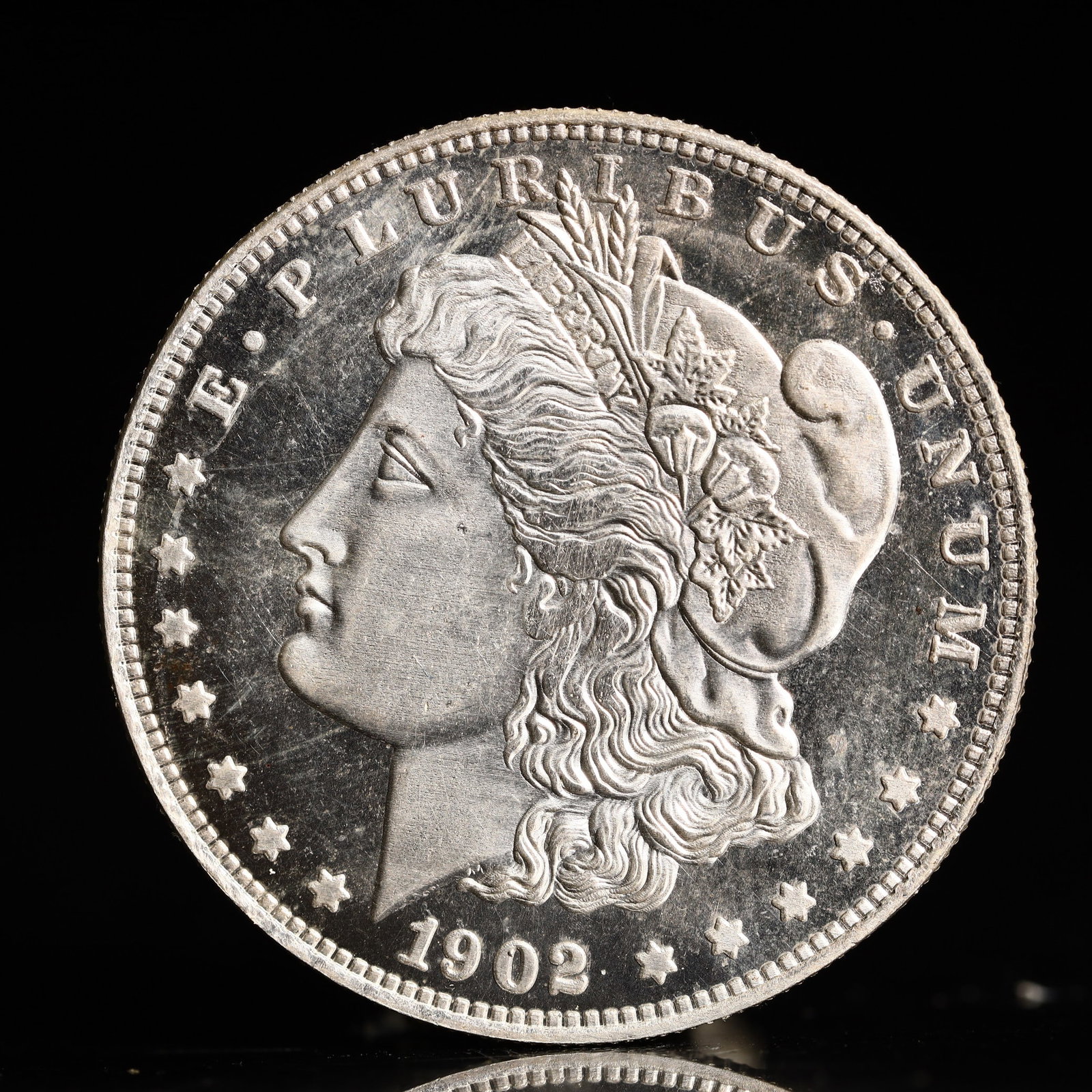 USA Morgan Dollar 1902 Coin: Obv: profile bust with date below and E PLURIBUS UNUM legend and stars around. Rev: eagle with In God we trust above within wreath with UNITED STATES OF AMERICA ONE DOLLAR legend. IN GOD WE TRUST / LI