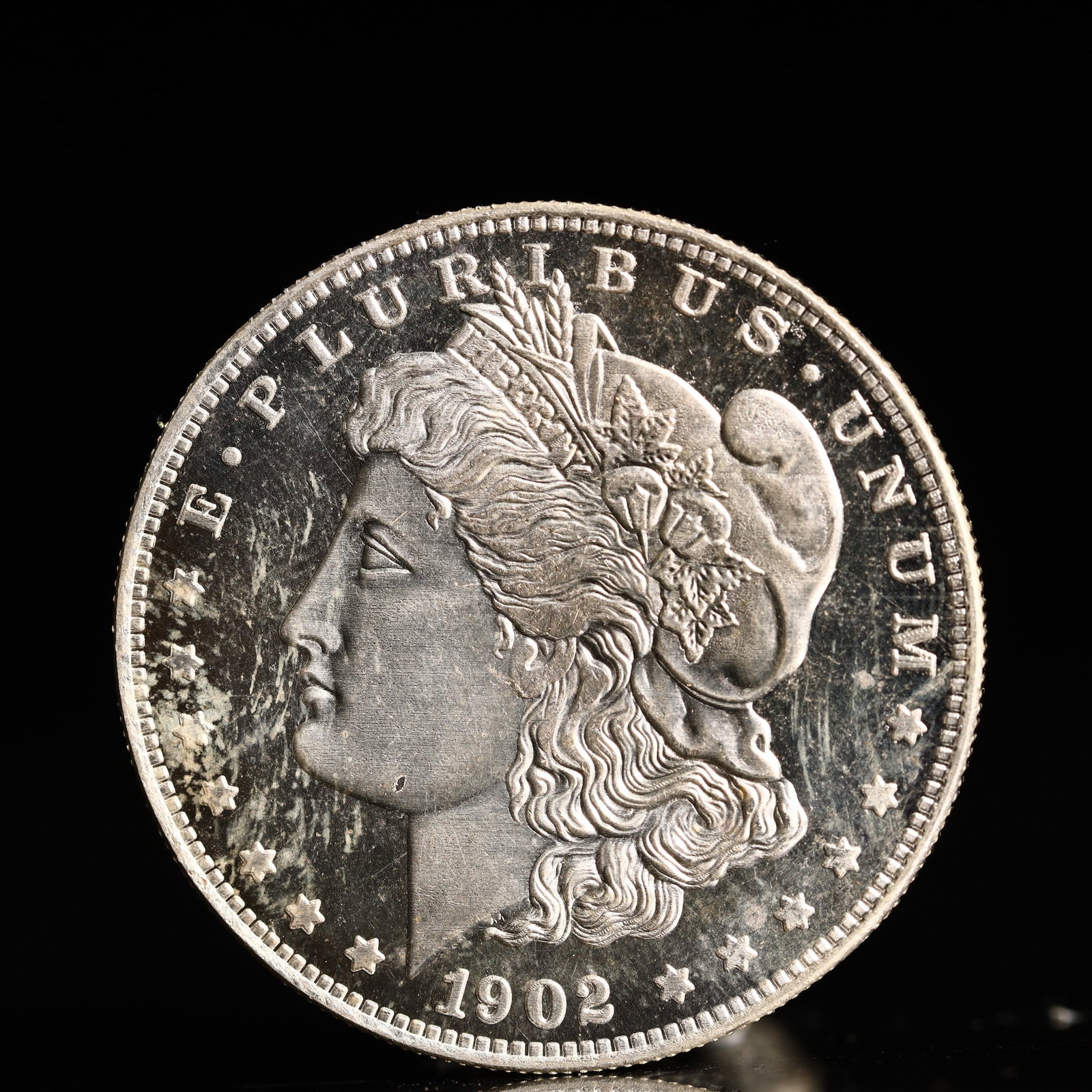 USA Morgan Dollar 1902 Coin: Obv: profile bust with date below and E PLURIBUS UNUM legend and stars around. Rev: eagle with In God we trust above within wreath with UNITED STATES OF AMERICA ONE DOLLAR legend. IN GOD WE TRUST / LI