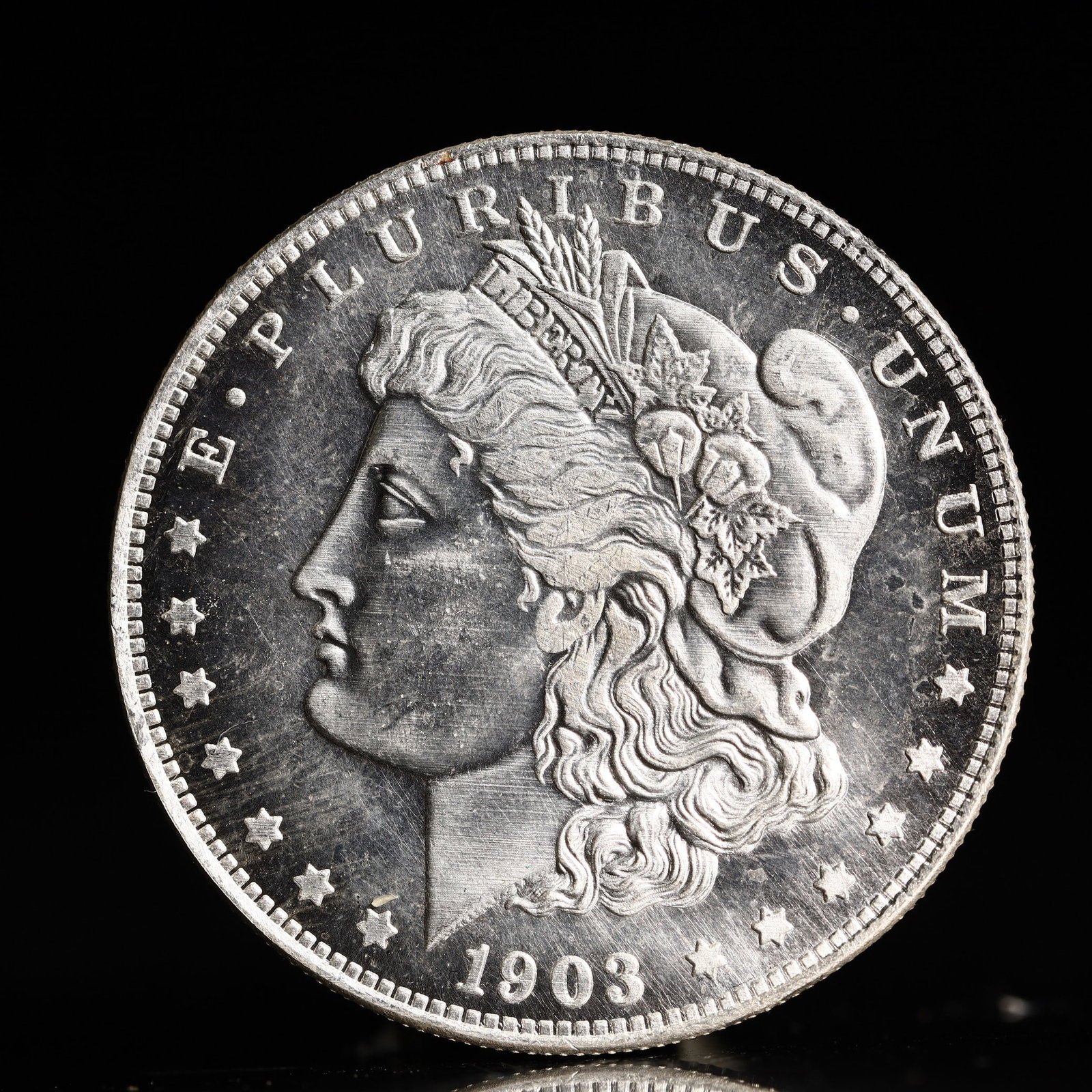 USA Morgan Dollar 1903 Coin: Obv: profile bust with date below and E PLURIBUS UNUM legend and stars around. Rev: eagle with In God we trust above within wreath with UNITED STATES OF AMERICA ONE DOLLAR legend. IN GOD WE TRUST / LI