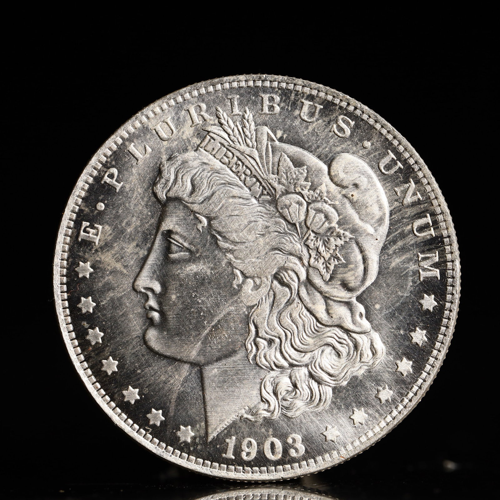 USA Morgan Dollar 1903 Coin: Obv: profile bust with date below and E PLURIBUS UNUM legend and stars around. Rev: eagle with In God we trust above within wreath with UNITED STATES OF AMERICA ONE DOLLAR legend. IN GOD WE TRUST / LI