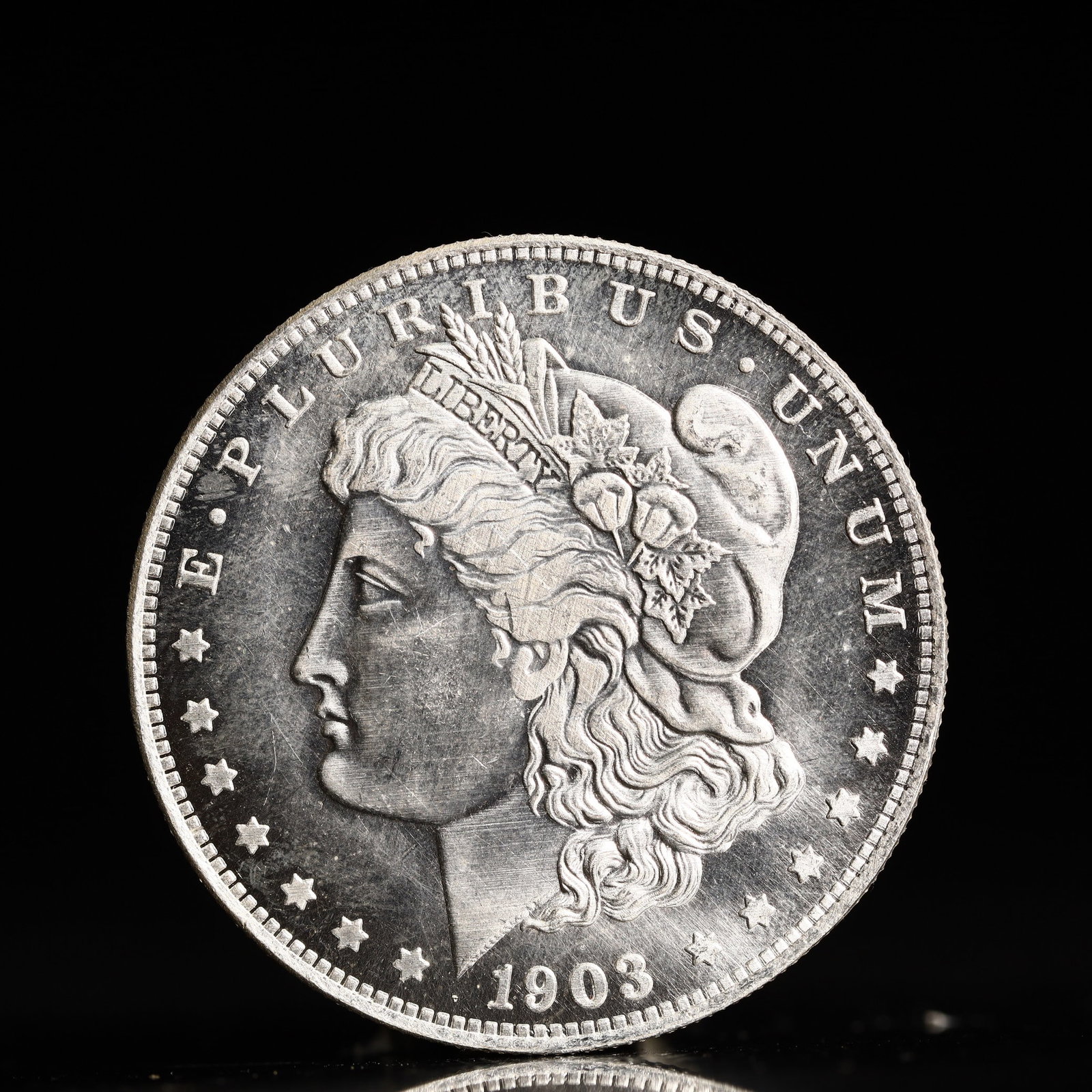USA Morgan Dollar 1903 Coin: Obv: profile bust with date below and E PLURIBUS UNUM legend and stars around. Rev: eagle with In God we trust above within wreath with UNITED STATES OF AMERICA ONE DOLLAR legend. IN GOD WE TRUST / LI
