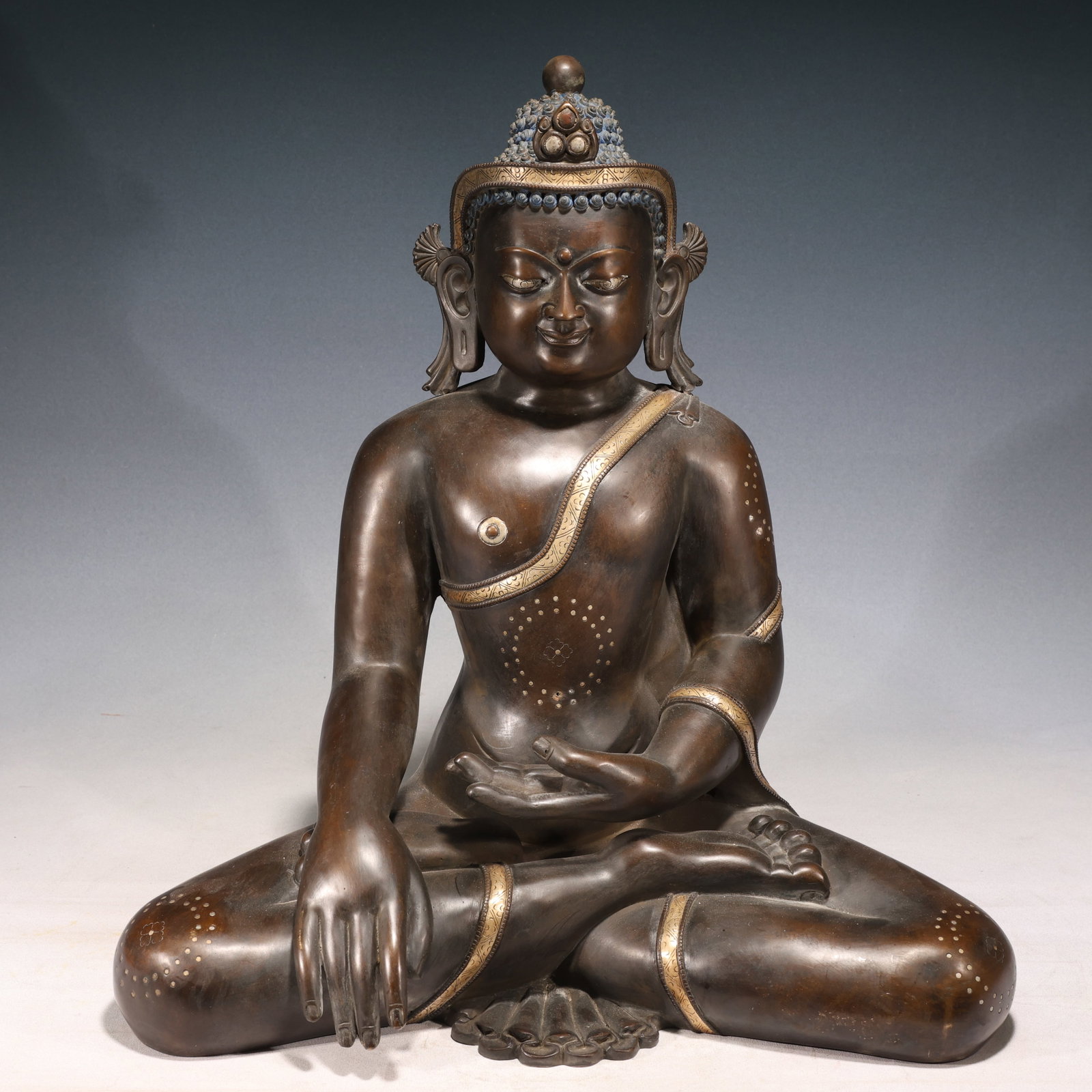 A Solemn Gilt Bronze Inlaid Silver Statue of Sakyamuni: A Solemn Gilt Bronze Inlaid Silver Statue of Sakyamuni,Qing Dynasty, China,Size:17.7inx9.8inx19.7in,Weight:19250g 铜鎏金嵌银如来像,中国ę