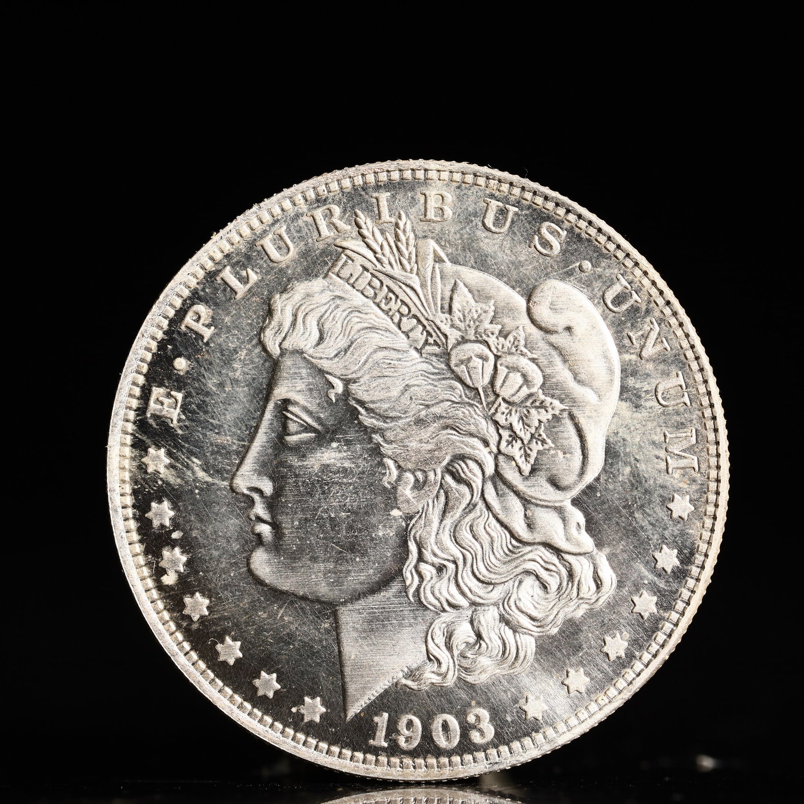 USA Morgan Dollar 1903 Coin: Obv: profile bust with date below and E PLURIBUS UNUM legend and stars around. Rev: eagle with In God we trust above within wreath with UNITED STATES OF AMERICA ONE DOLLAR legend. IN GOD WE TRUST / LI
