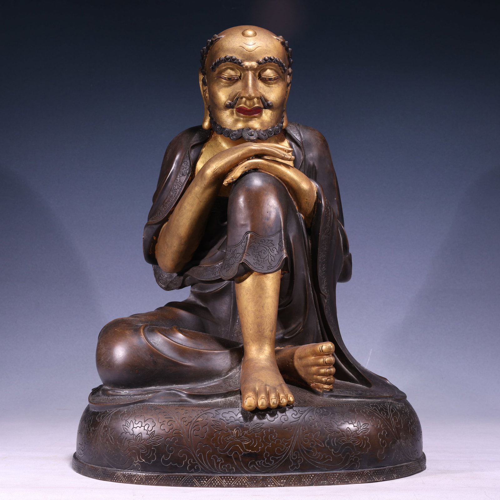 A Solemn Gilt Bronze Lotus Pattern Statue of Arhat: A Solemn Gilt Bronze Lotus Pattern Statue of Arhat,Qing Dynasty, China,Size:15.7inx13.4inx21.3in,Weight:21350g 铜鎏金缠枝莲纹罗汉像,中