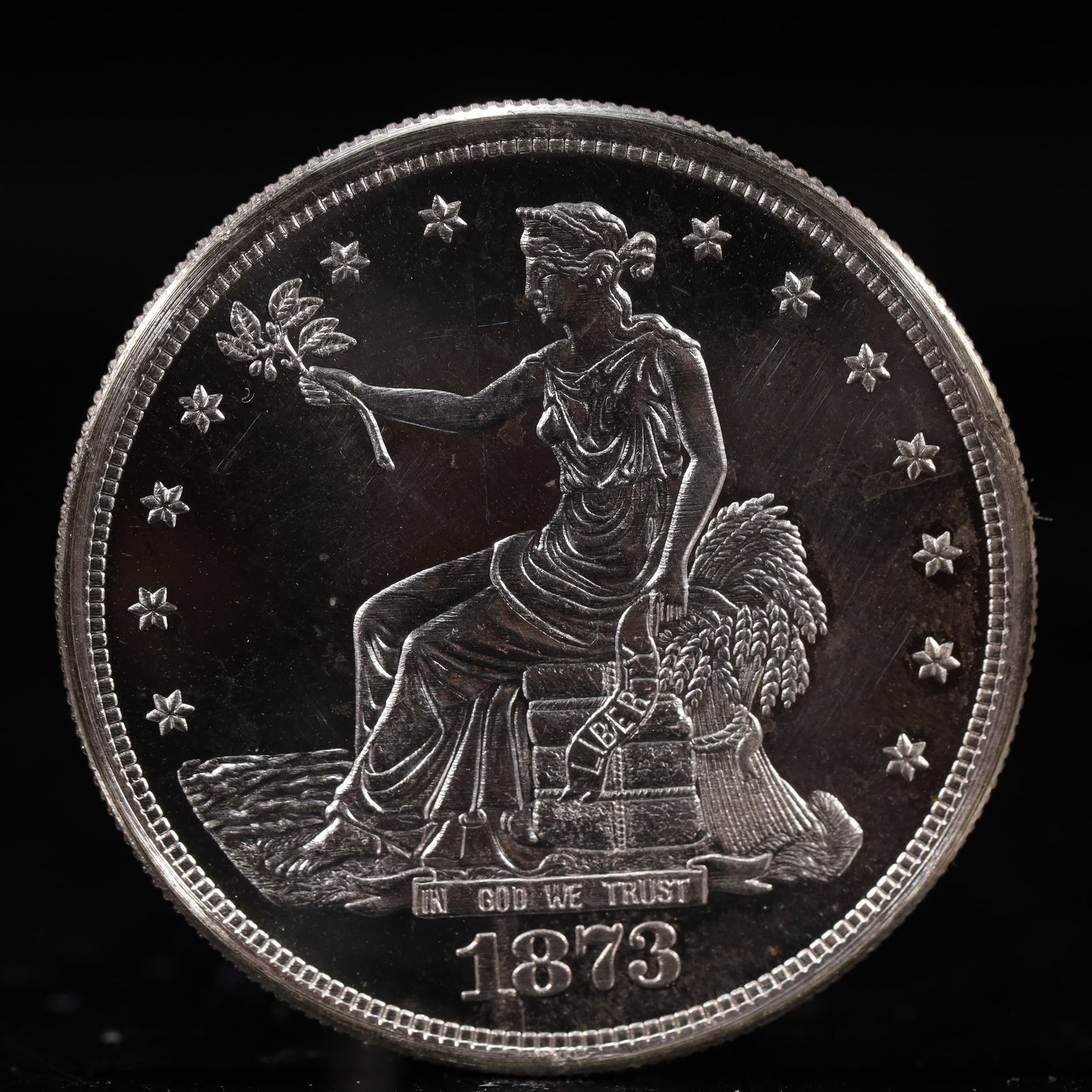 USA Trade Dollar 1873 Coin: American coin. Obverse: Liberty seated on a pedestal facing the sea to the left holding olive branches surrounded by 13 stars. IN GOD WE TRUST / LIBERTY / 1873. Reverse: An eagle holding branches