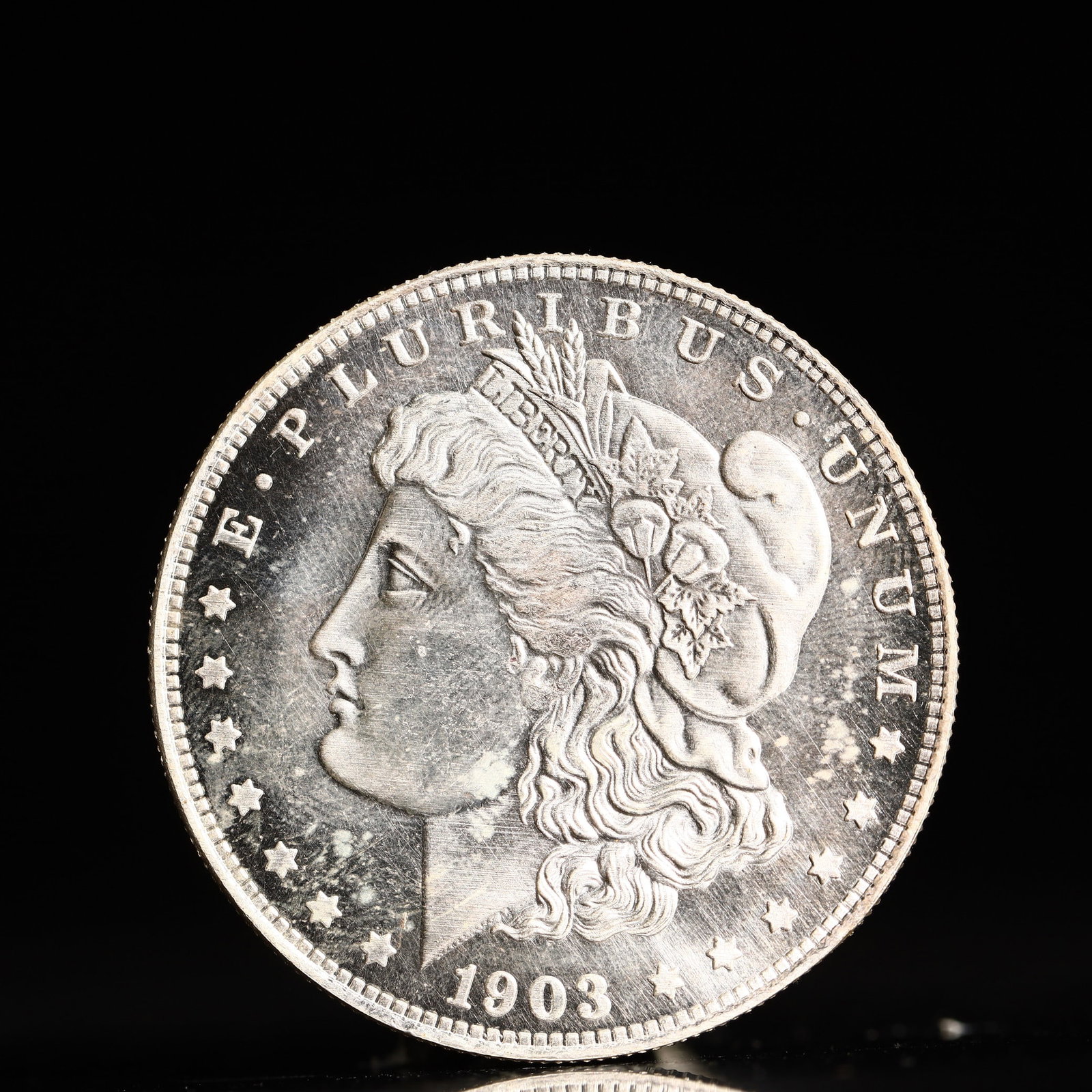USA Morgan Dollar 1903 Coin: Obv: profile bust with date below and E PLURIBUS UNUM legend and stars around. Rev: eagle with In God we trust above within wreath with UNITED STATES OF AMERICA ONE DOLLAR legend. IN GOD WE TRUST / LI